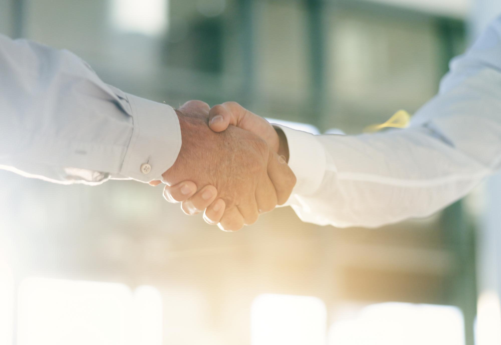 Two men shake hands on an office