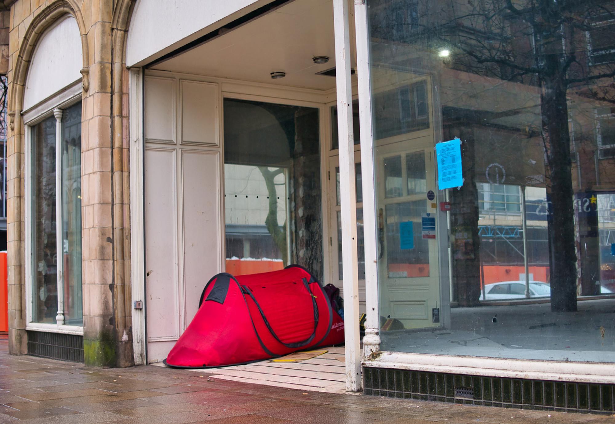 a small red tent outside a closed shop