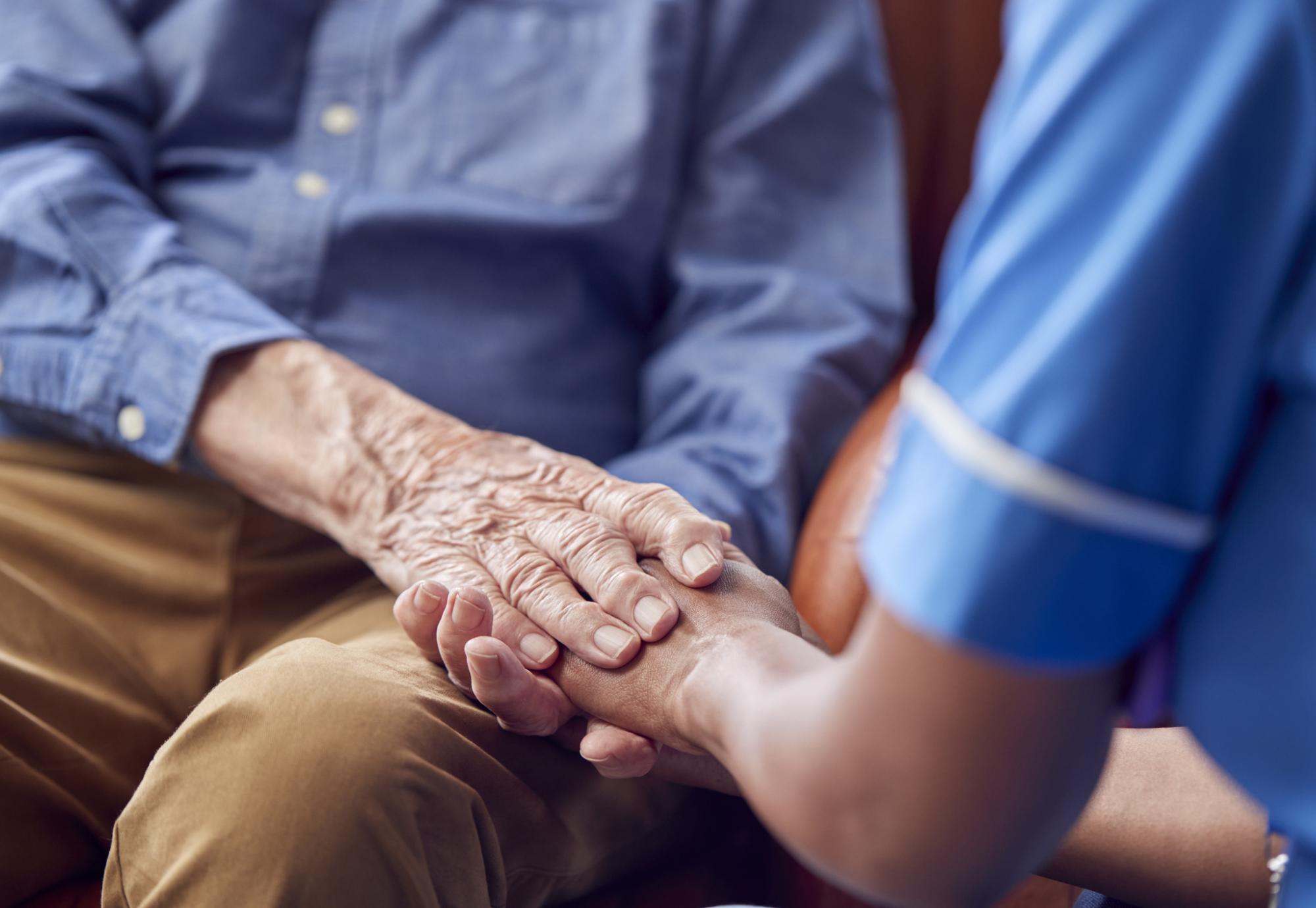 Nurse holding mans hand