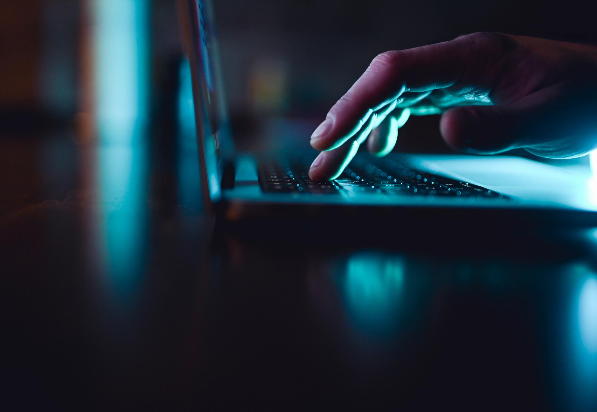 Hand using a laptop keyboard