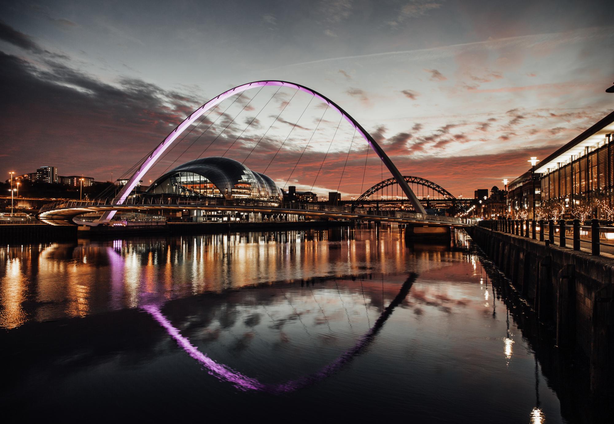 Millennium bridge at sunset with the Tyne Bridge in the background