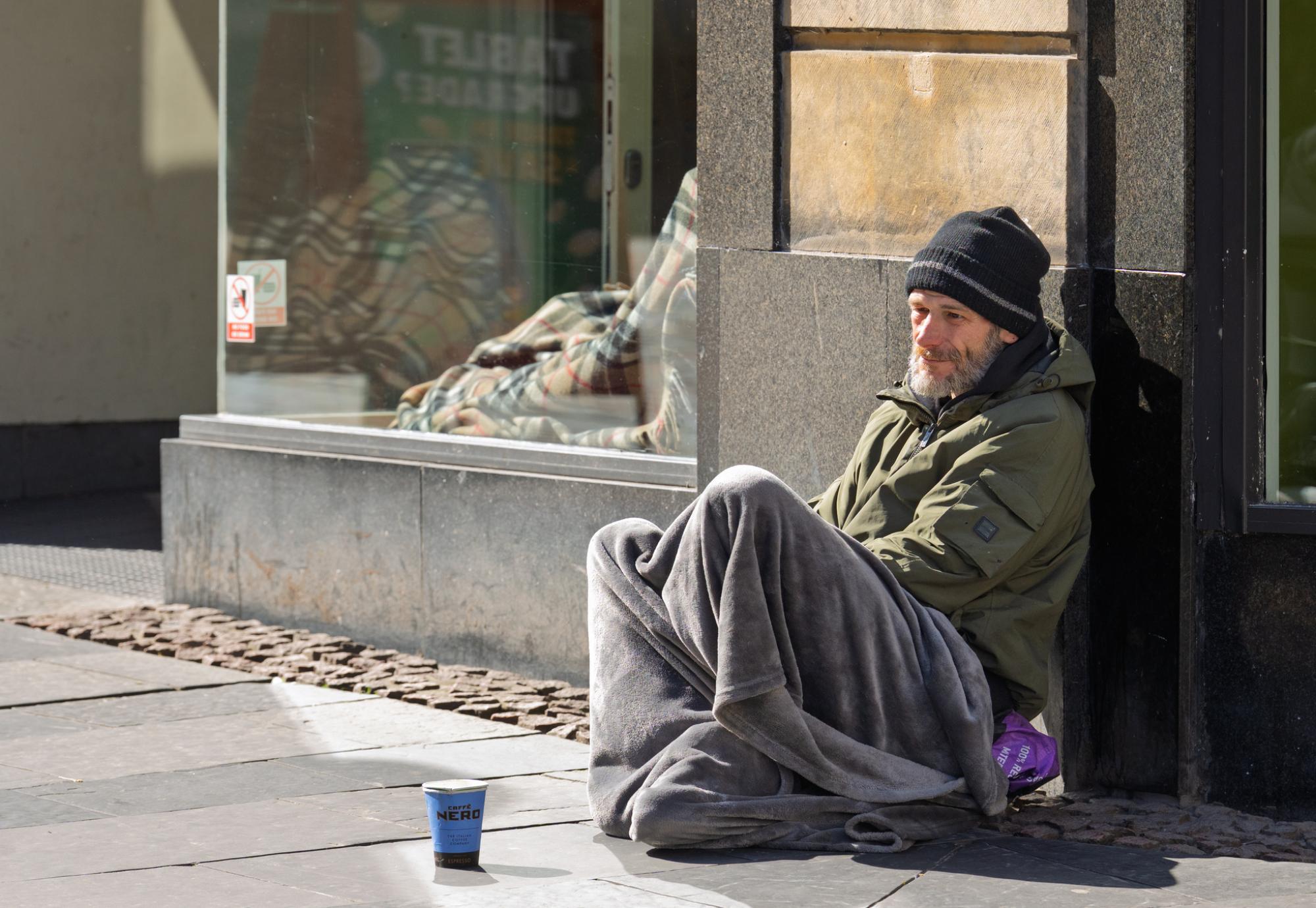 A homeless man sitting on the streets