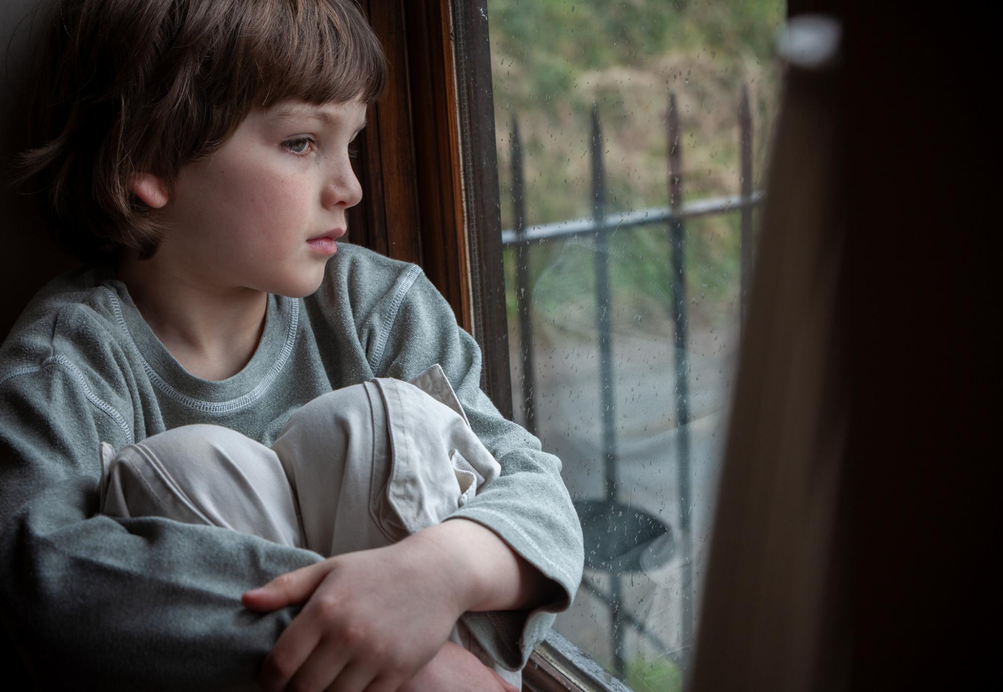 Young boy looking out of window
