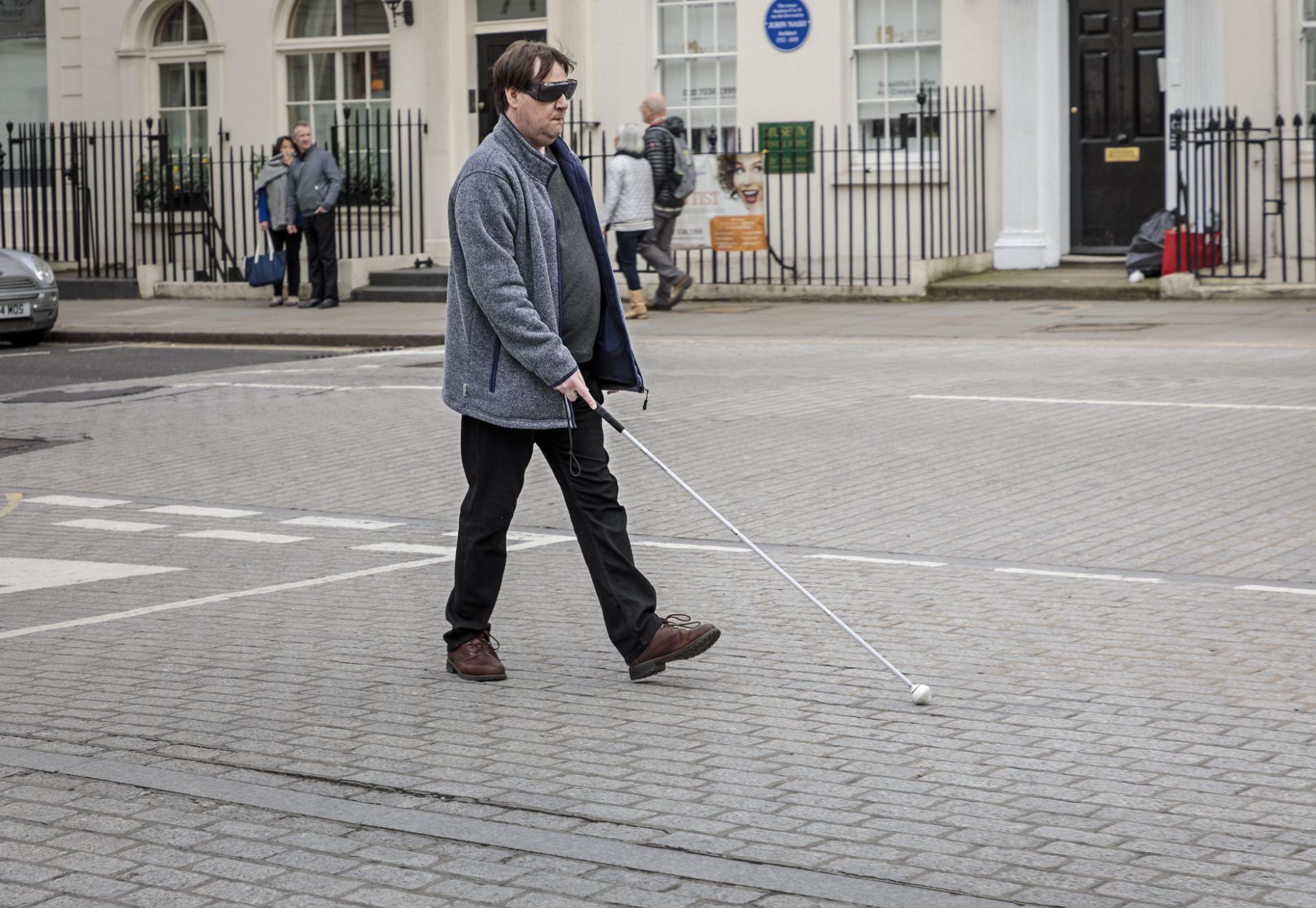 Blind man crossing the road in London