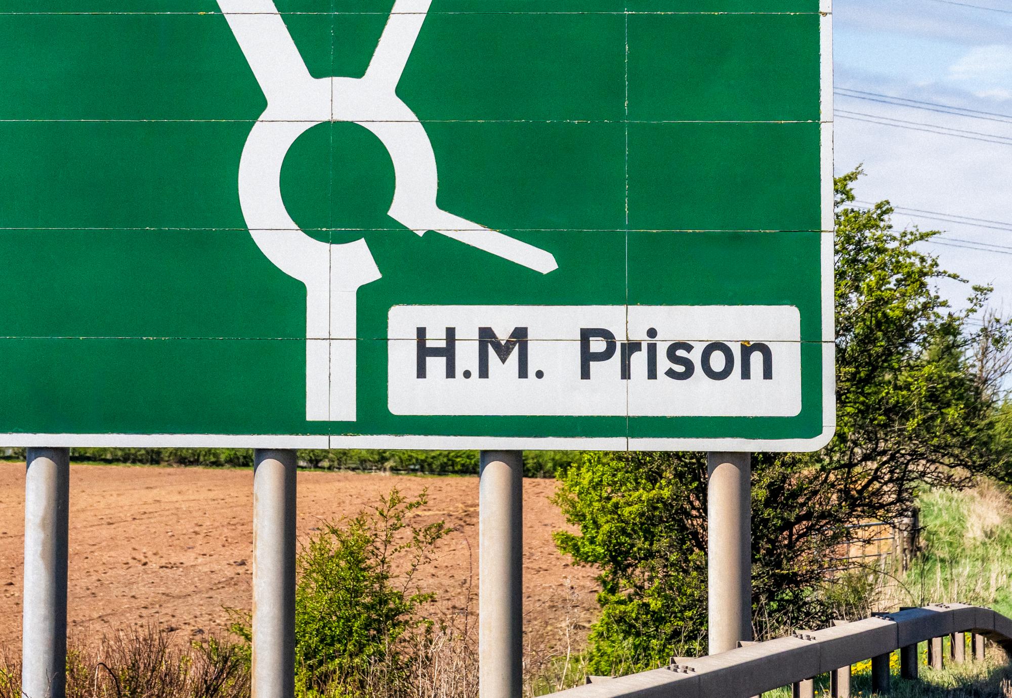 Prison sign next to a road