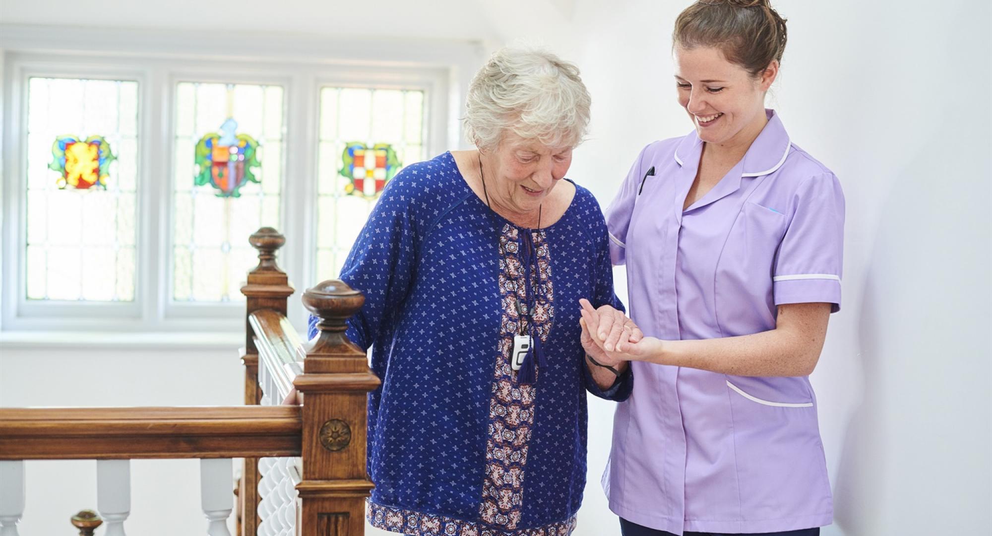 Carer helping elderly woman 