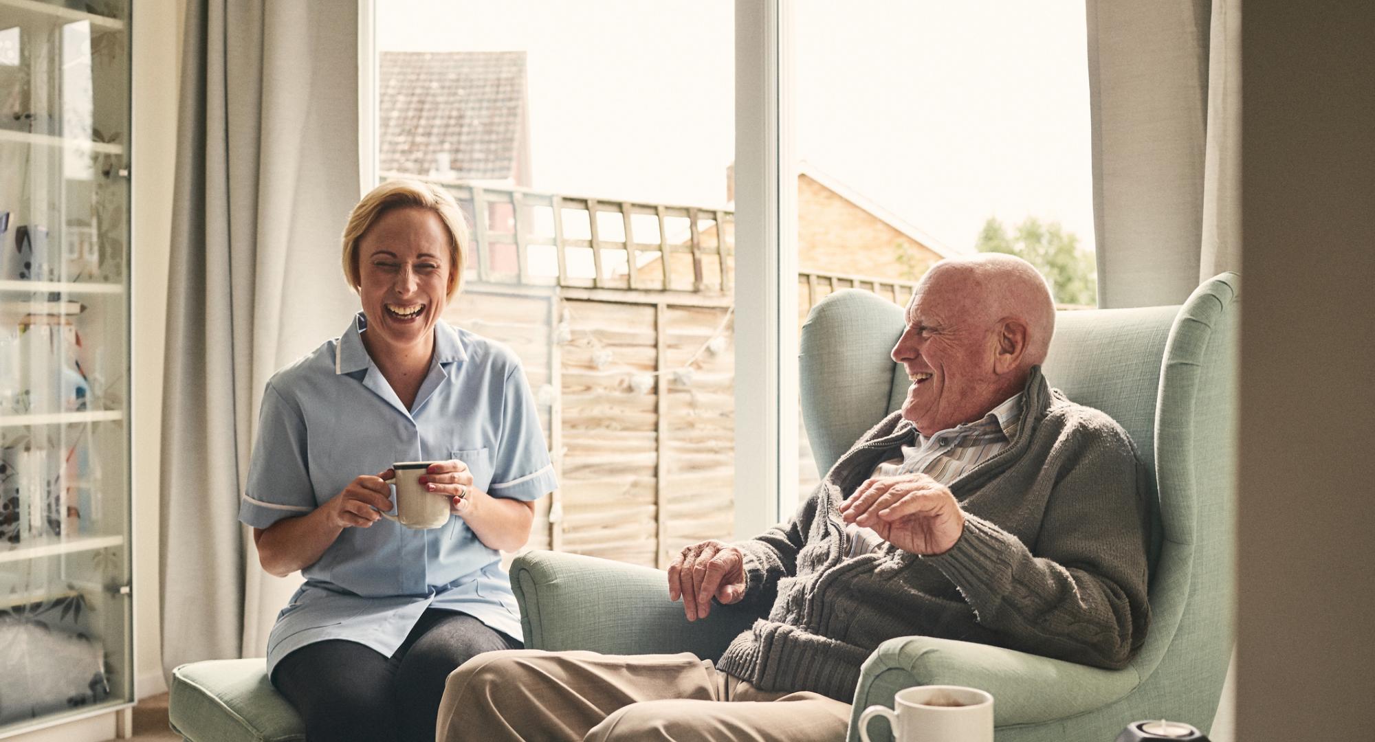 carer nurse laughing with older gentleman