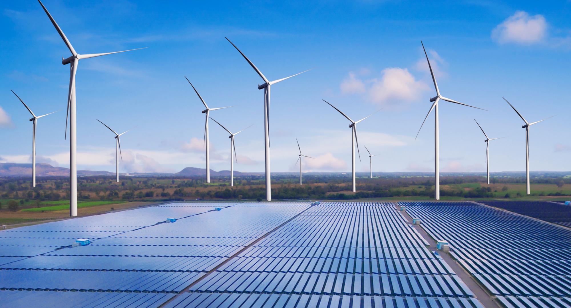 A field with wind turbine and solar panels.