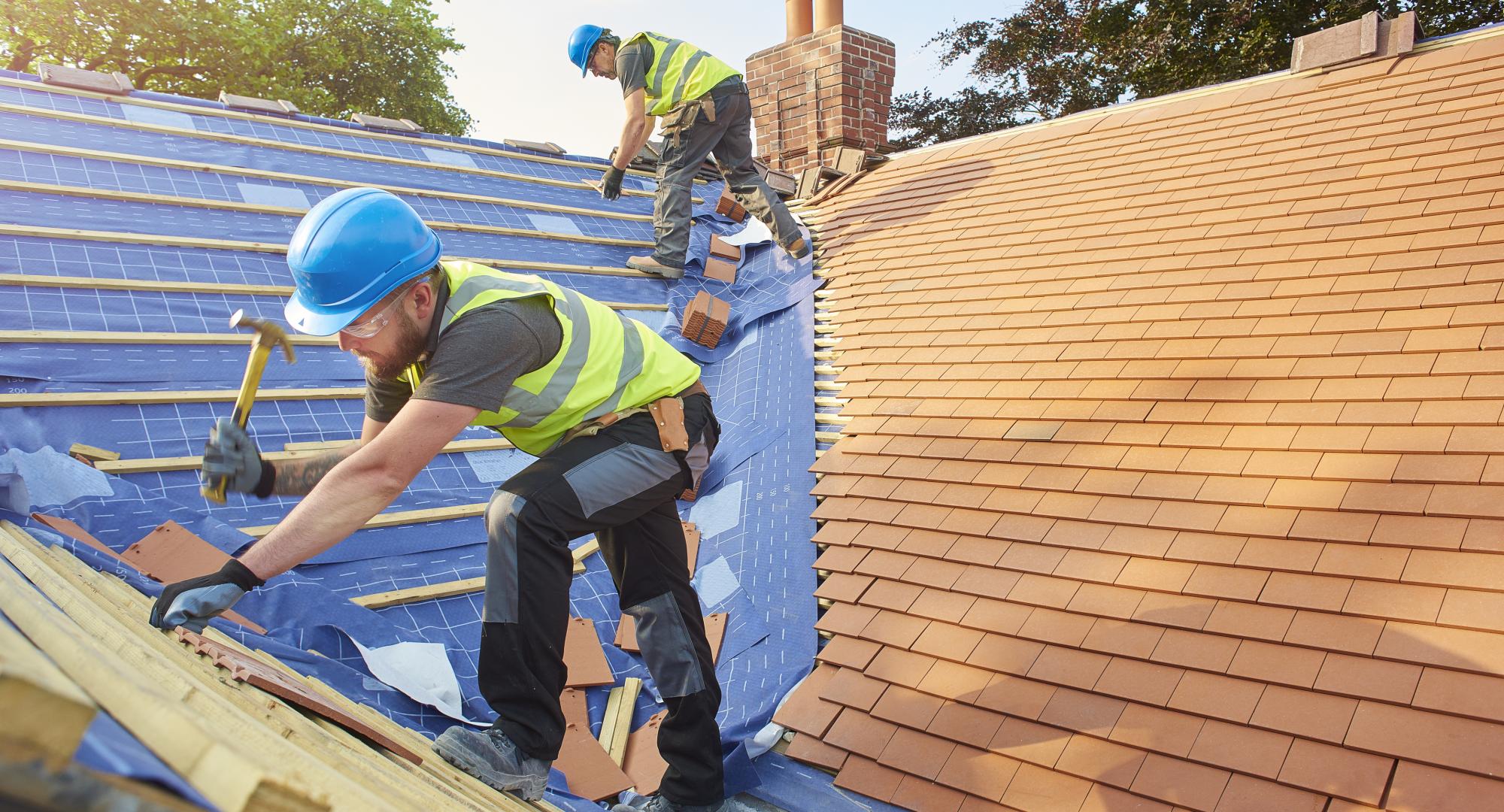 Builders tiling a roof