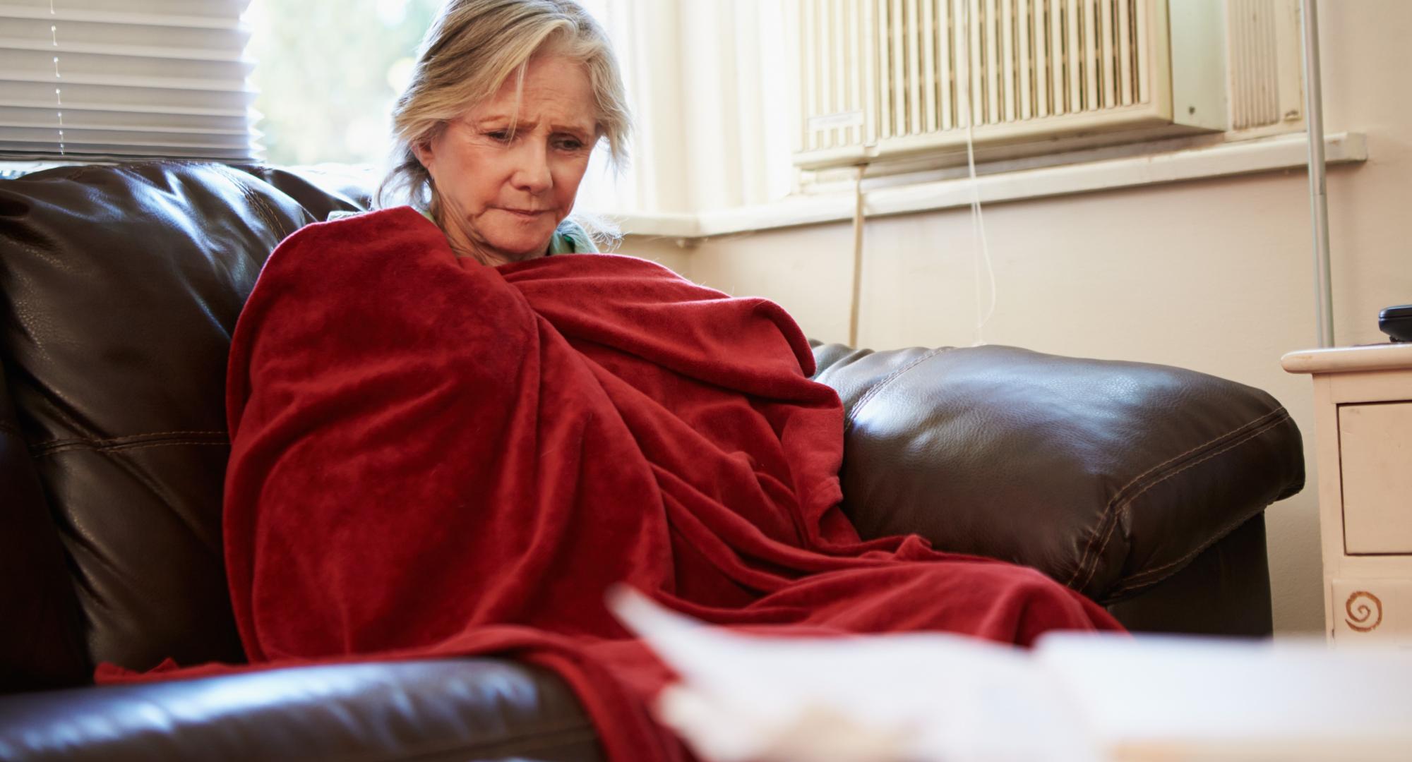 Woman is cold on couch.