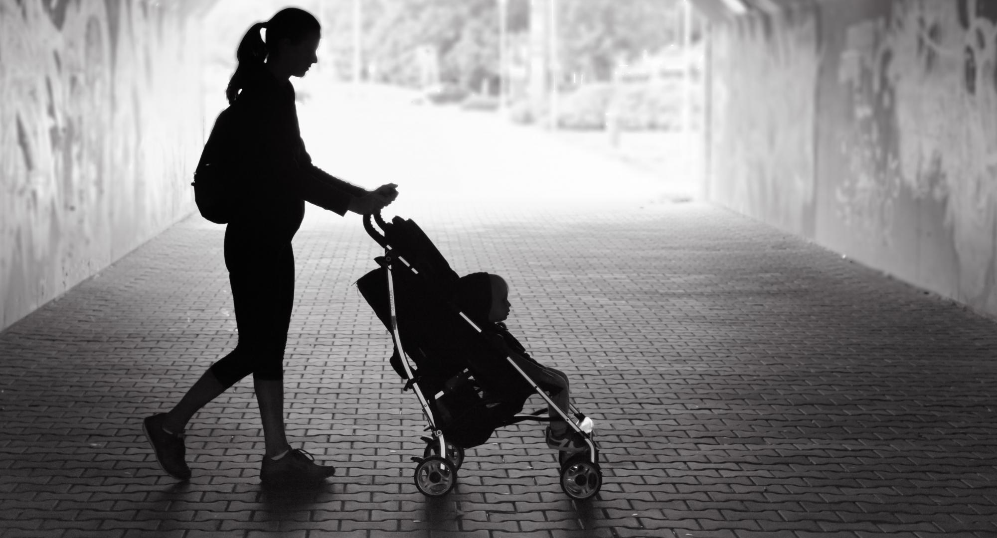 Black and white picture of single mum with pram.