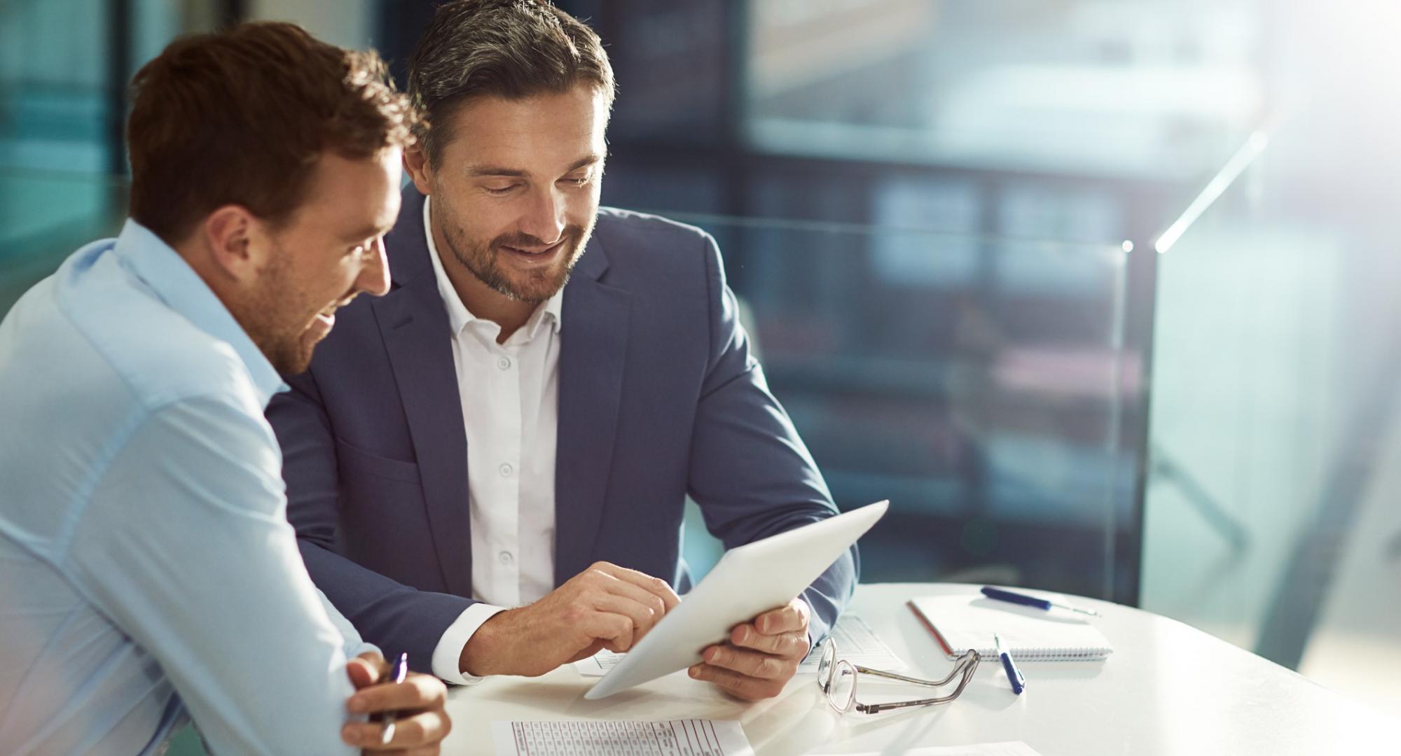Two businessmen in discussions over a document