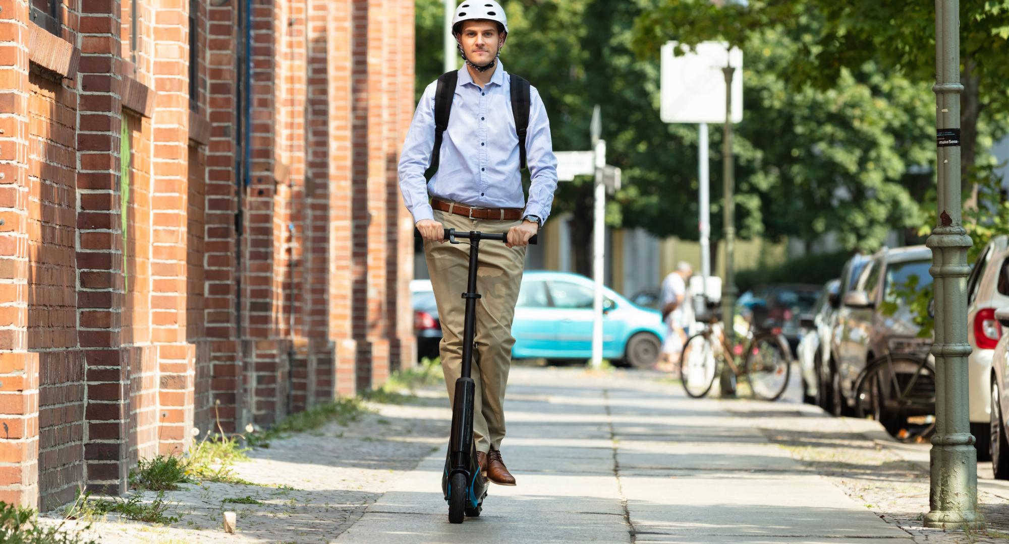 Man rides e-scooter through town