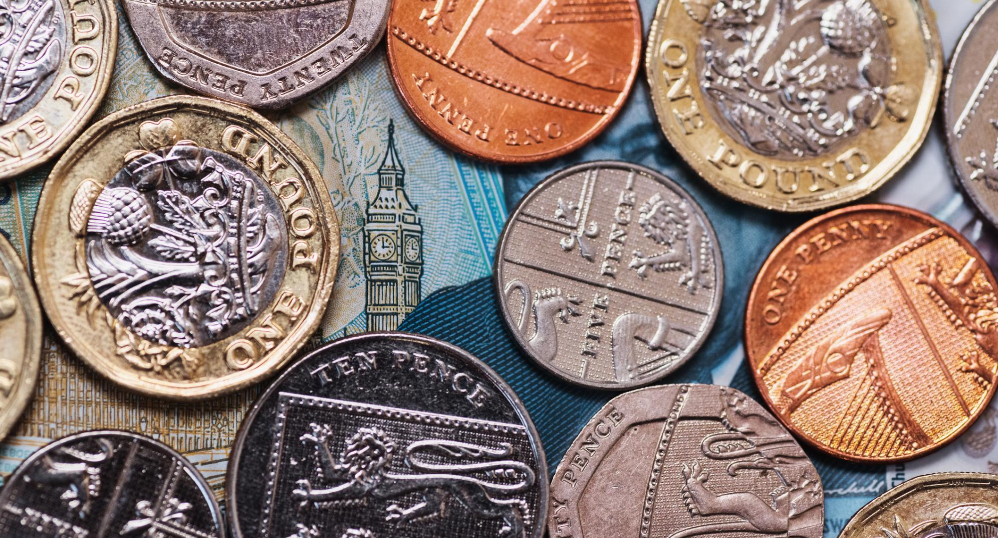 Coins placed over a five pound note revealing the Elizabeth Tower.
