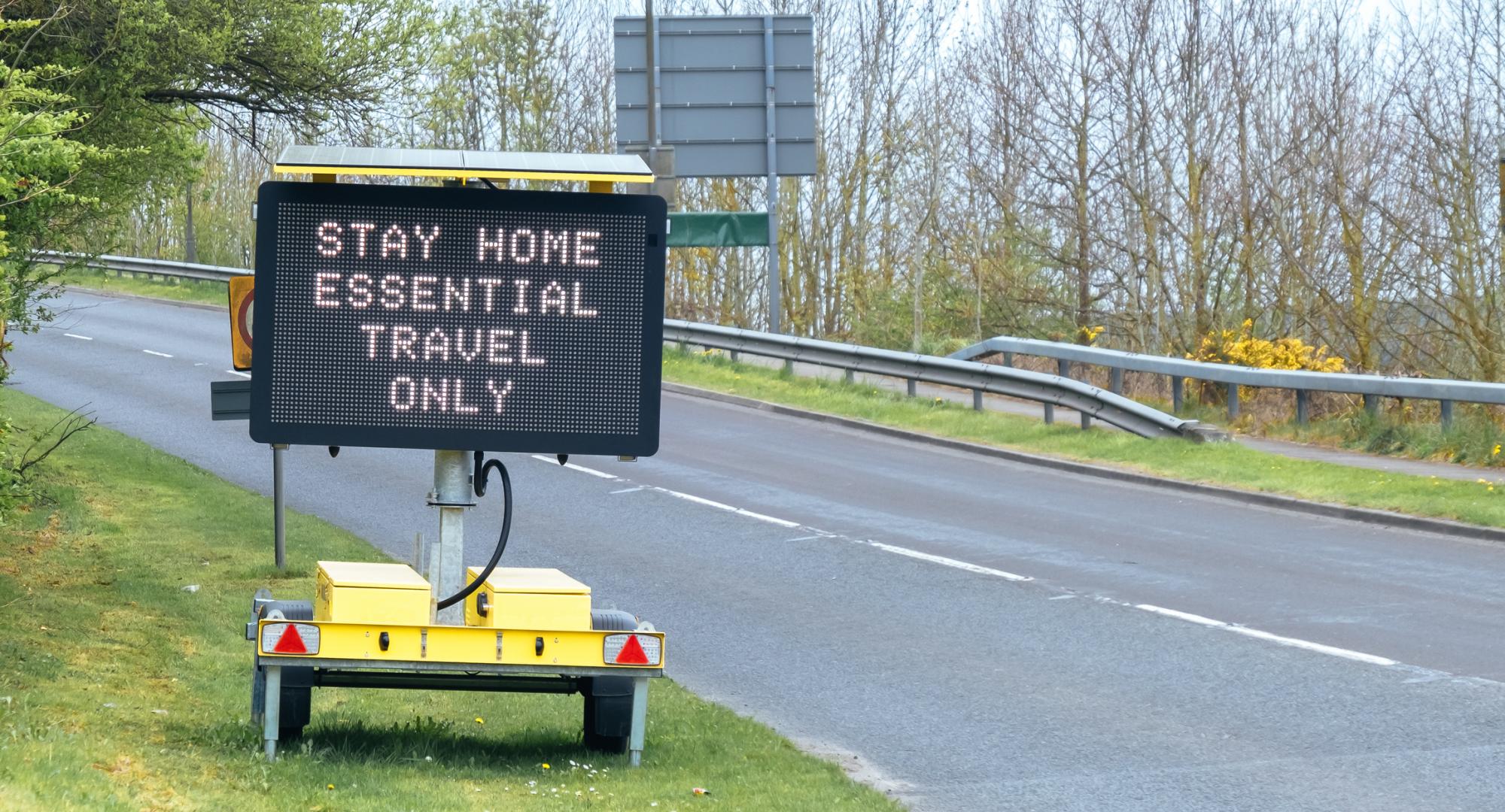 Sign tells motorists to stay at home, essential journeys only. 