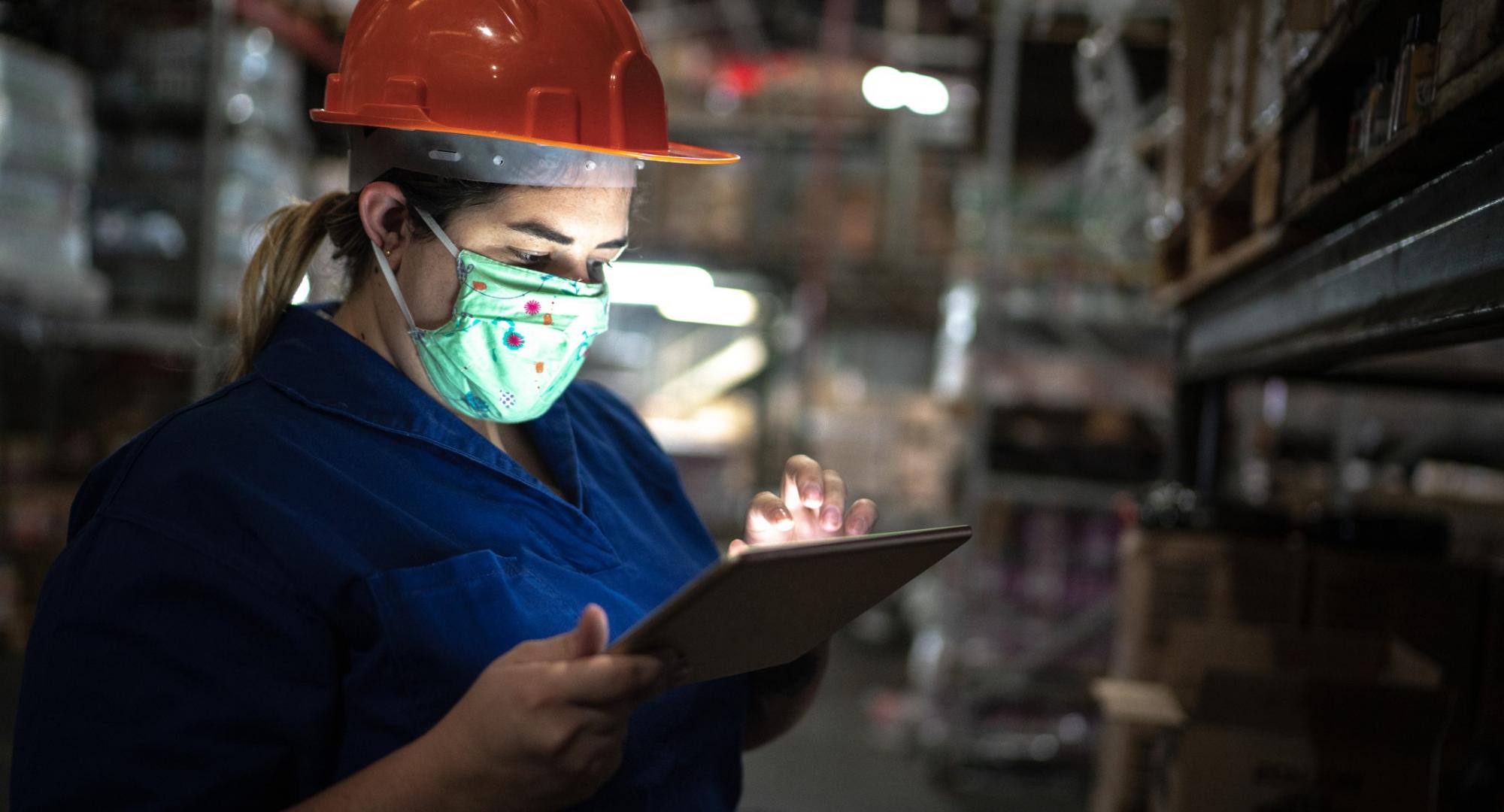 Girl in warehouse working on a tablet.