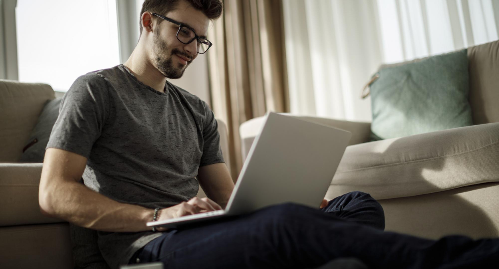 Man sits on his laptop at home doing online course.