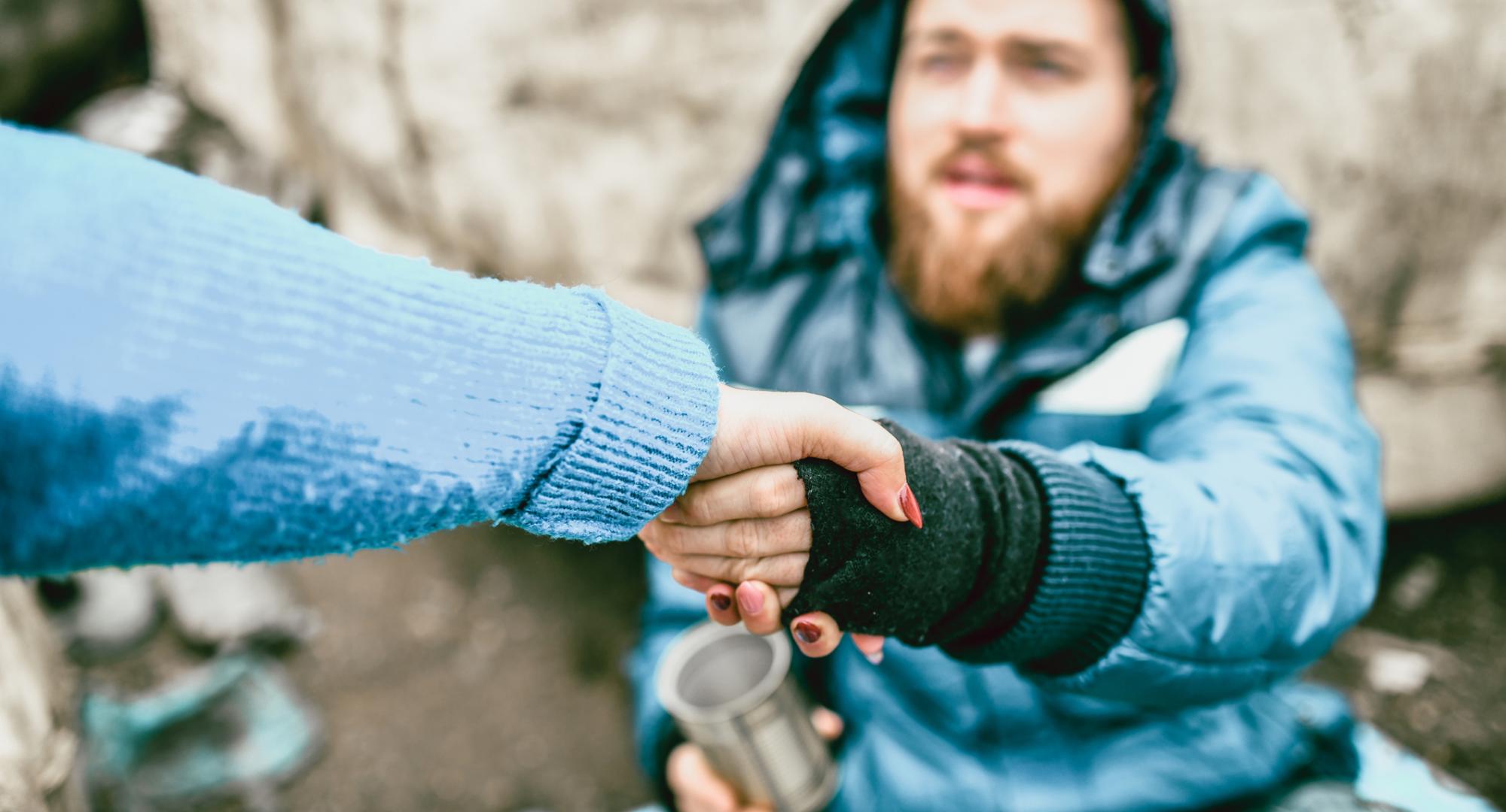 Homeless man is helped by passerby