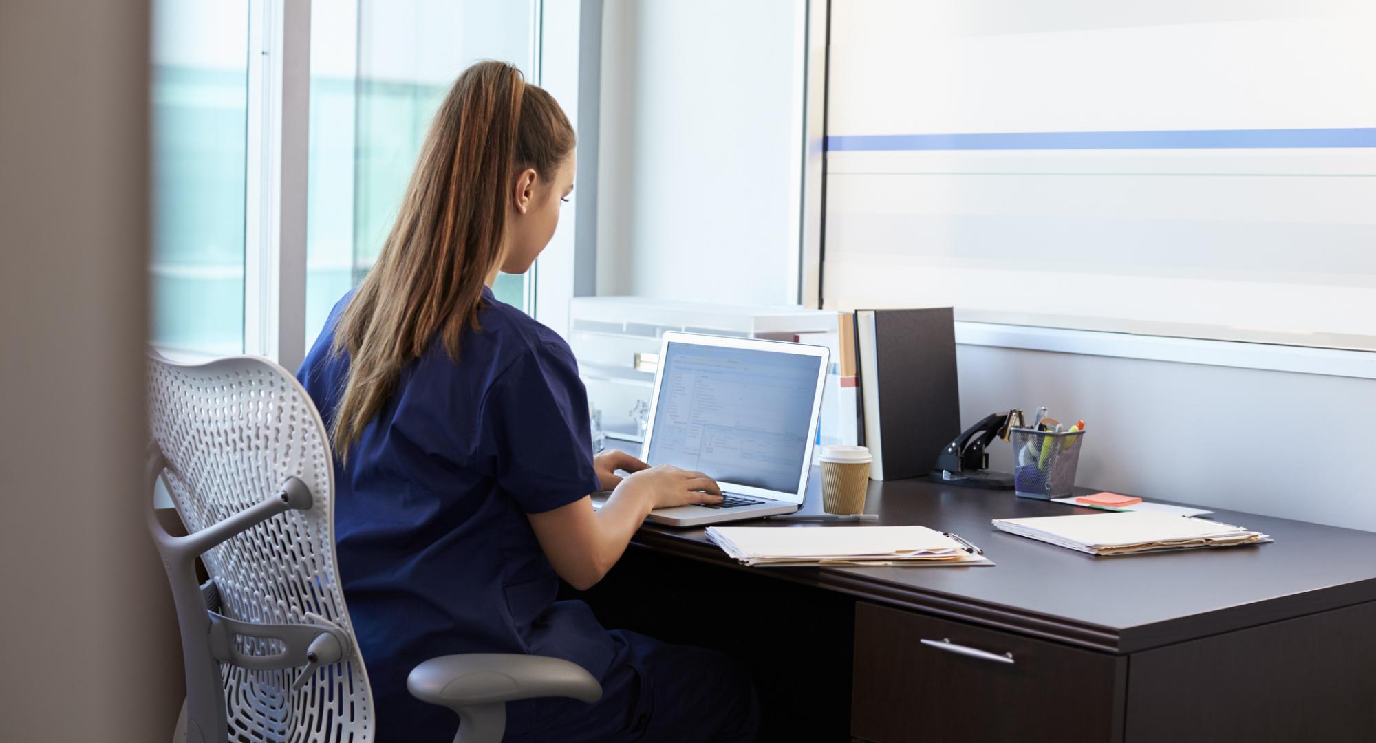 Student nurse sits at desk. 