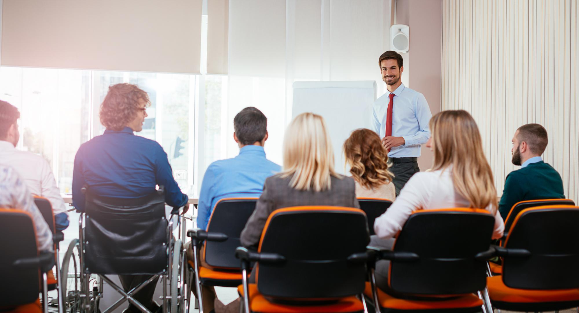 Man addresses a group of conference delegates