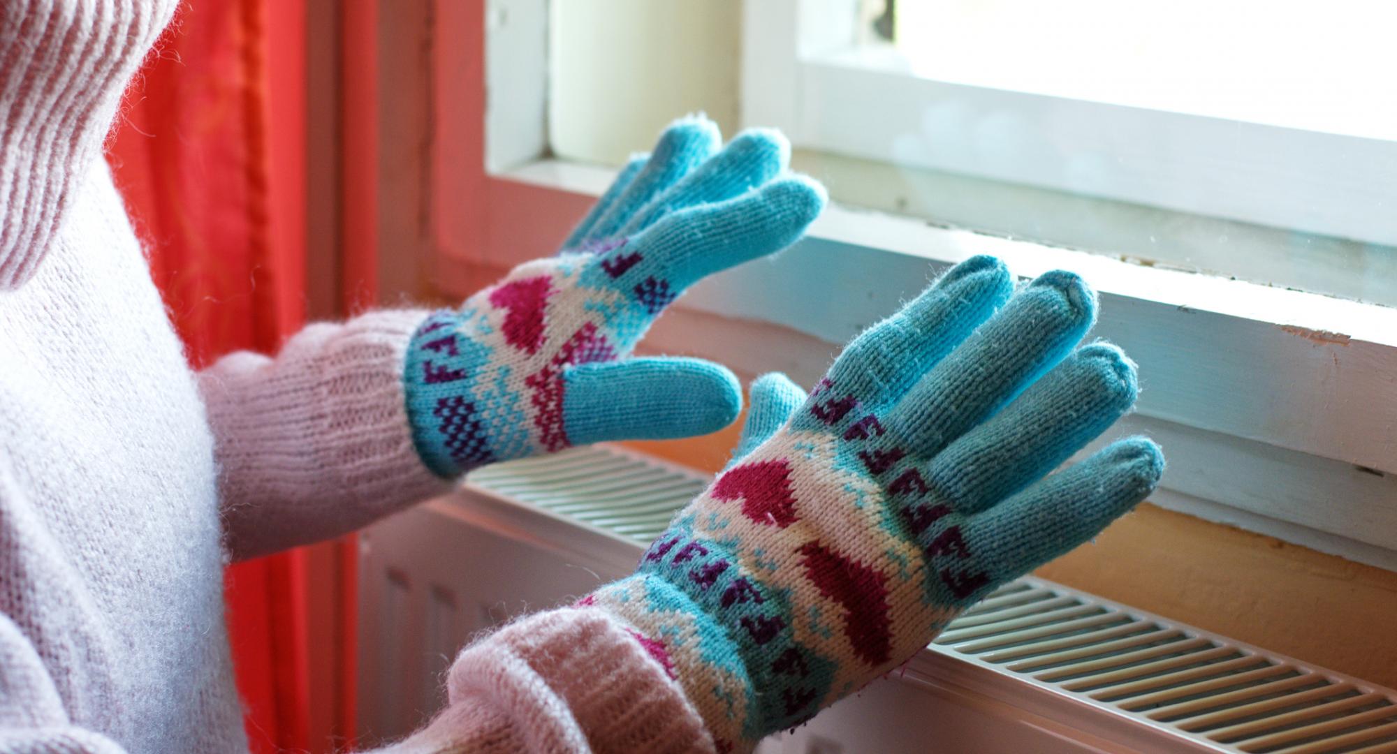 Person wearing gloves over radiator