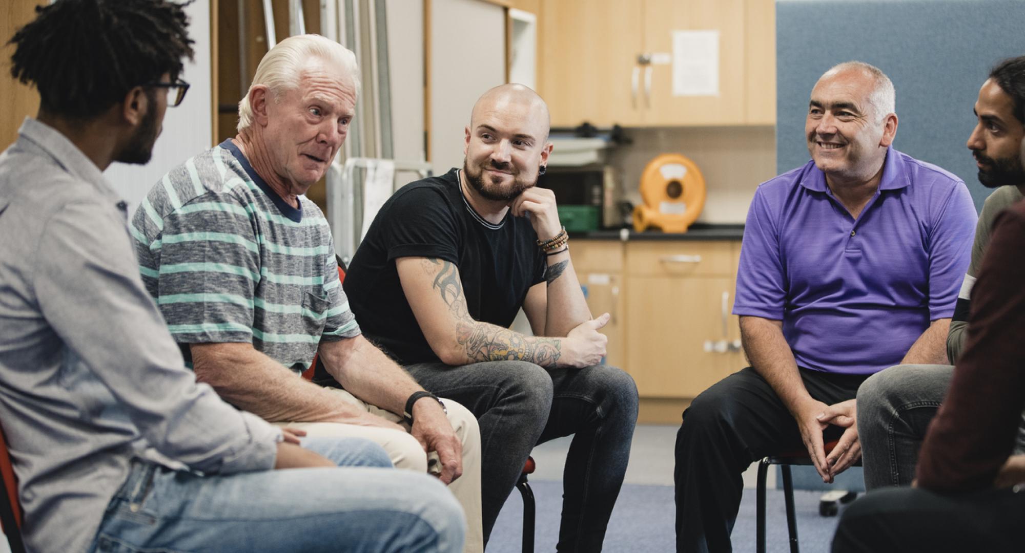 Group of men in community support meeting