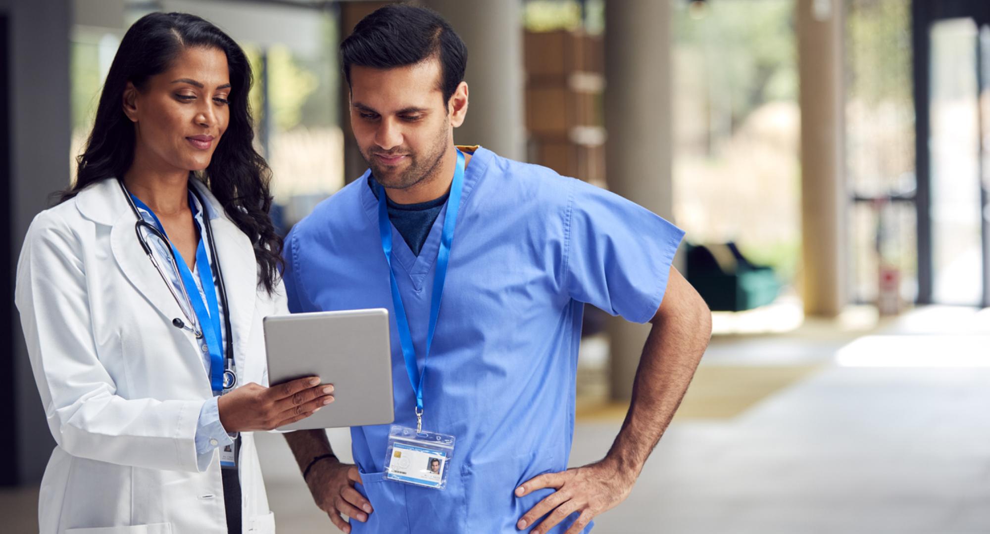 Two healthcare professionals looking at a tablet PC