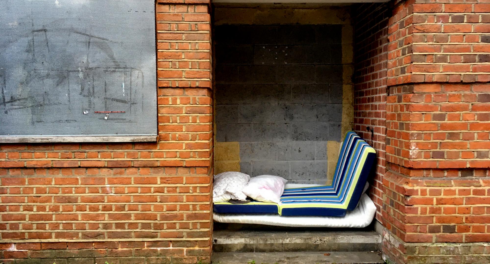 Mattresses stacked up in a doorway by a rough sleeper