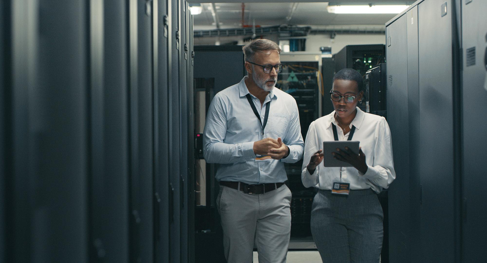 Two people walking through IT infrastructure