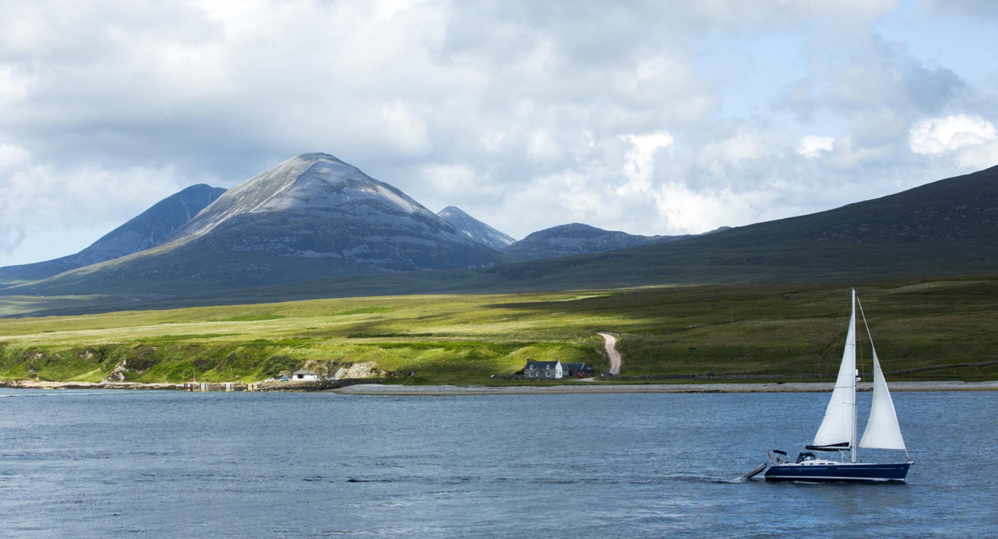 Panoramic view of Scottish island with a boat in the foreground