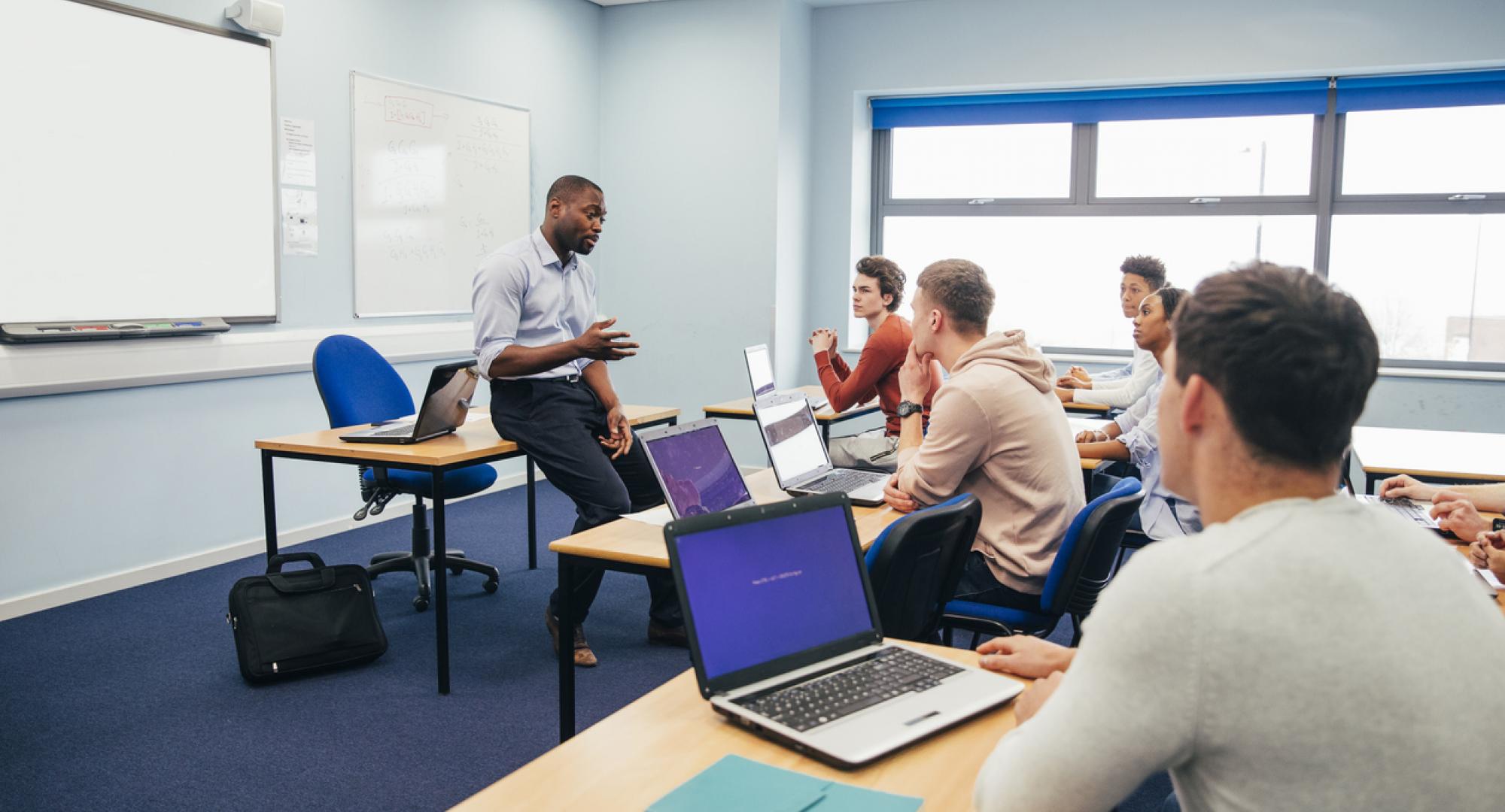 A male teaches a class of further education students