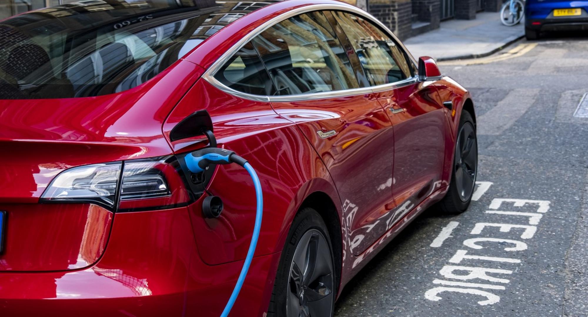 An electric vehicle charging at the side of the road