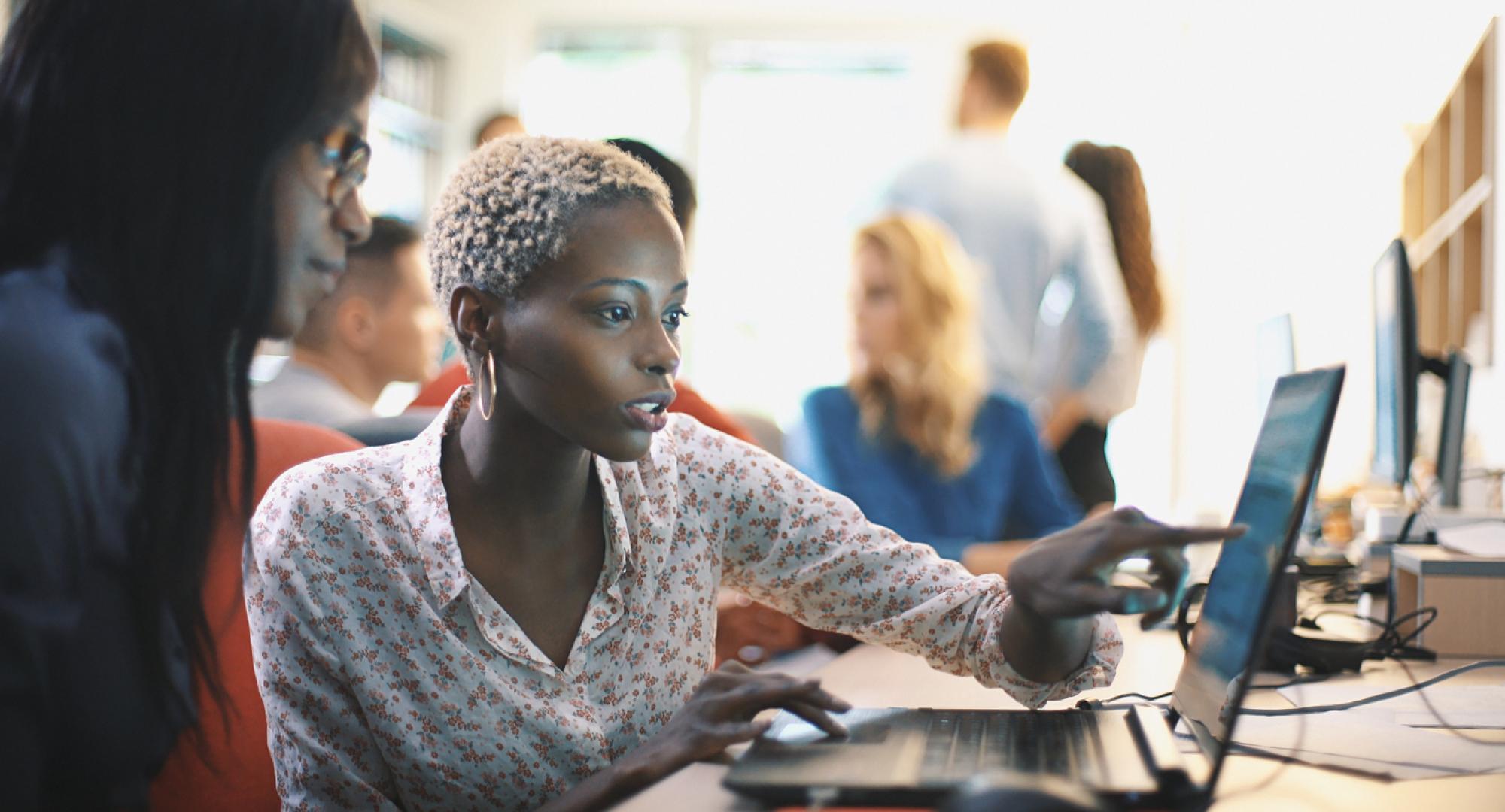 A woman points at a computer