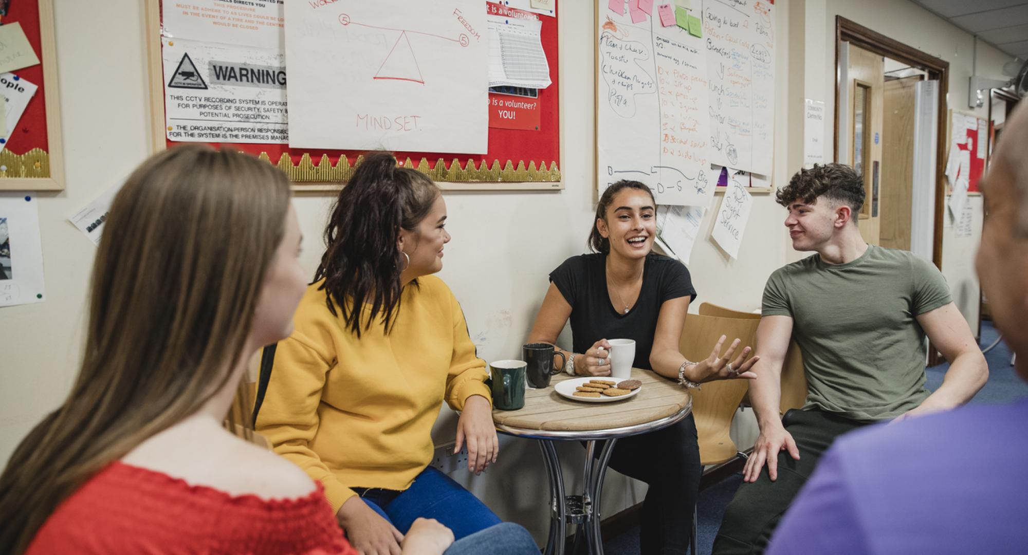 Group of young people sat together talking