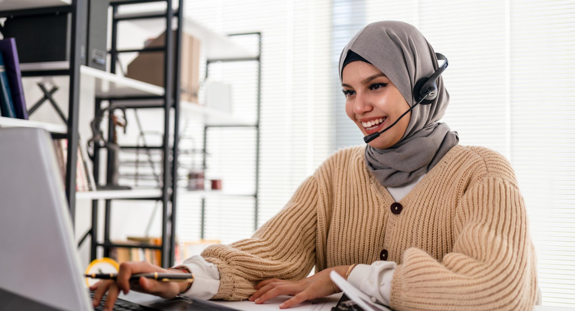 Lady in a hijab working at a computer in an office