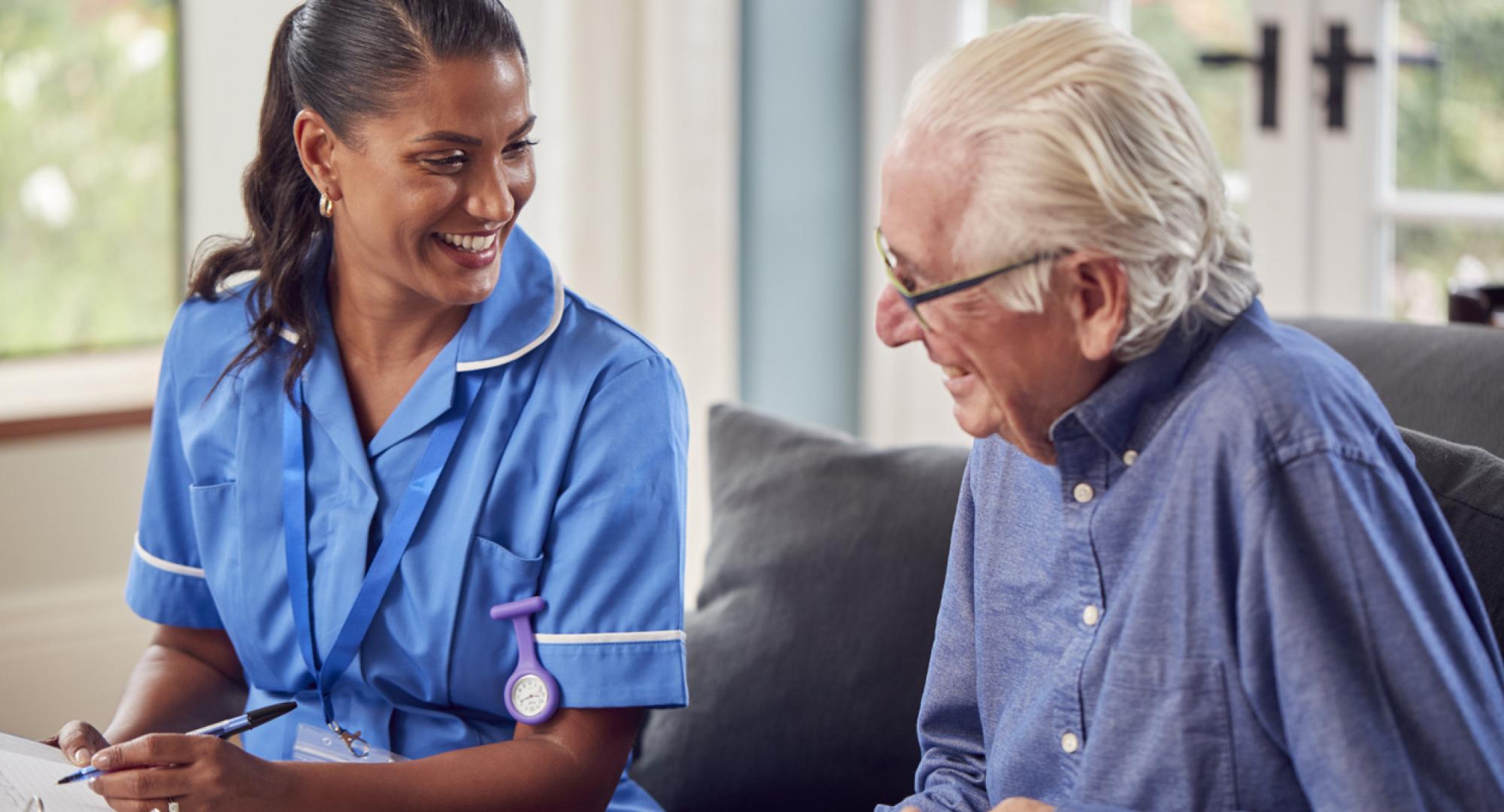 Older man talking to a nurse in his home