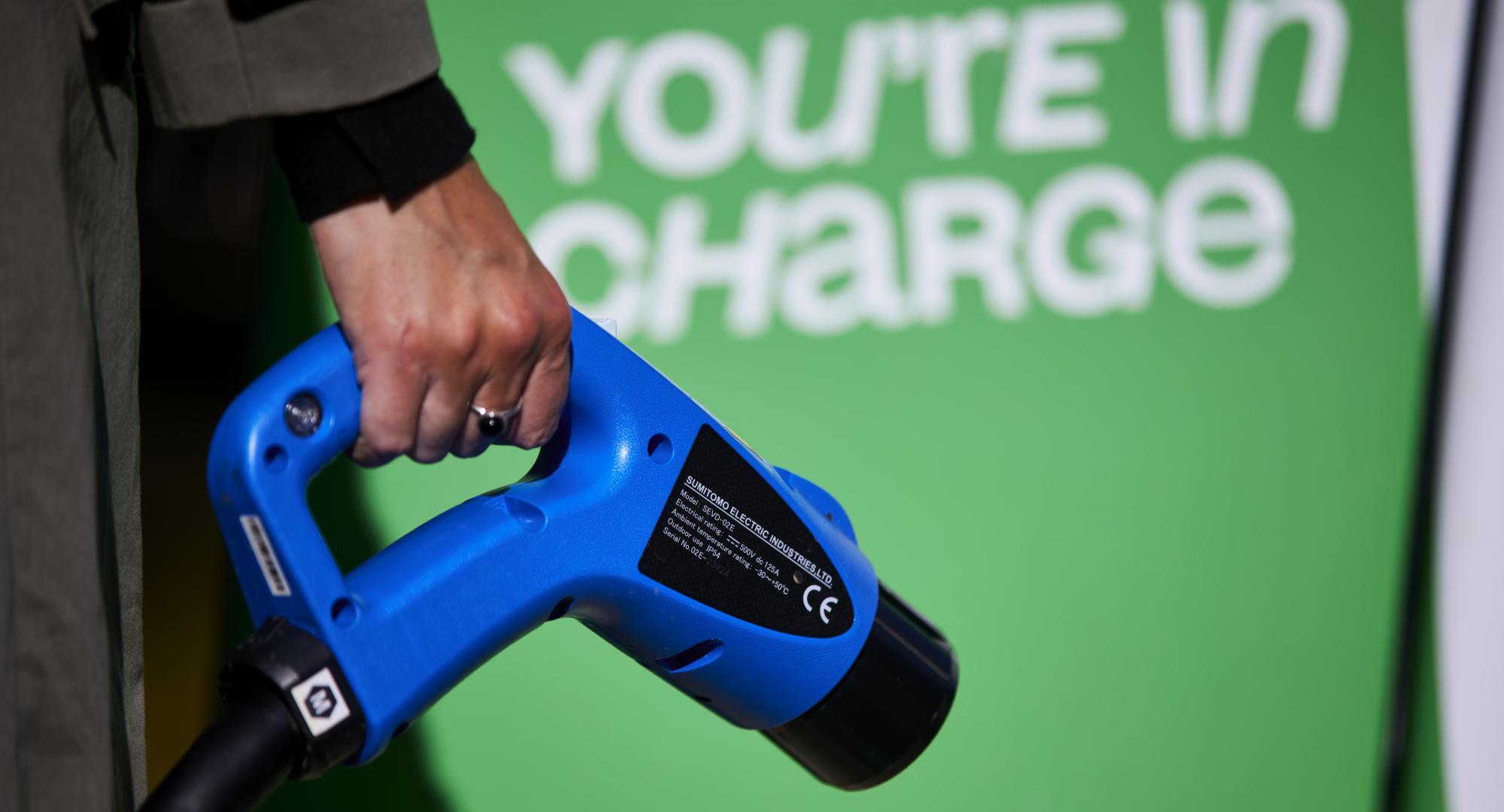Woman holding an electric vehicle charger