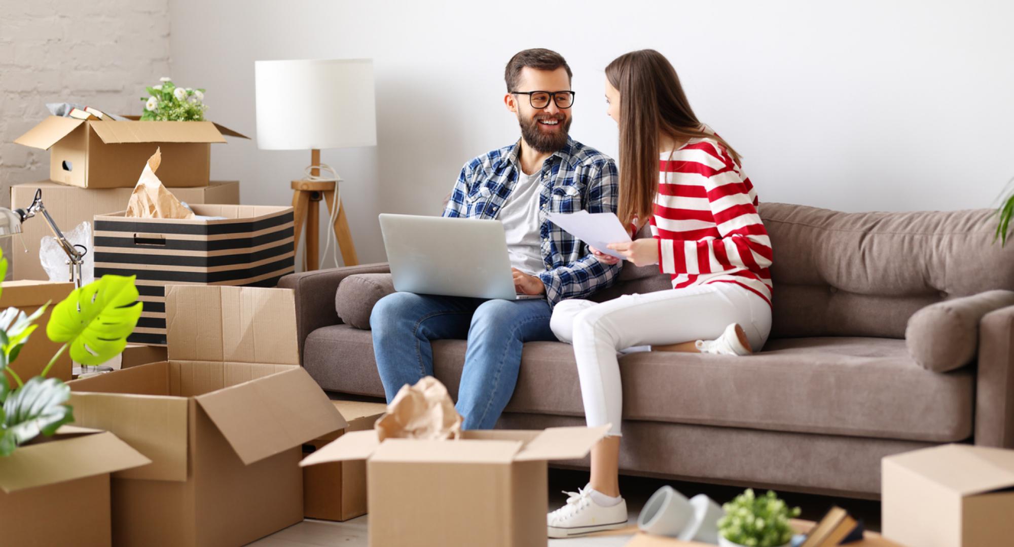 Couple in room full of boxes after moving into their first home