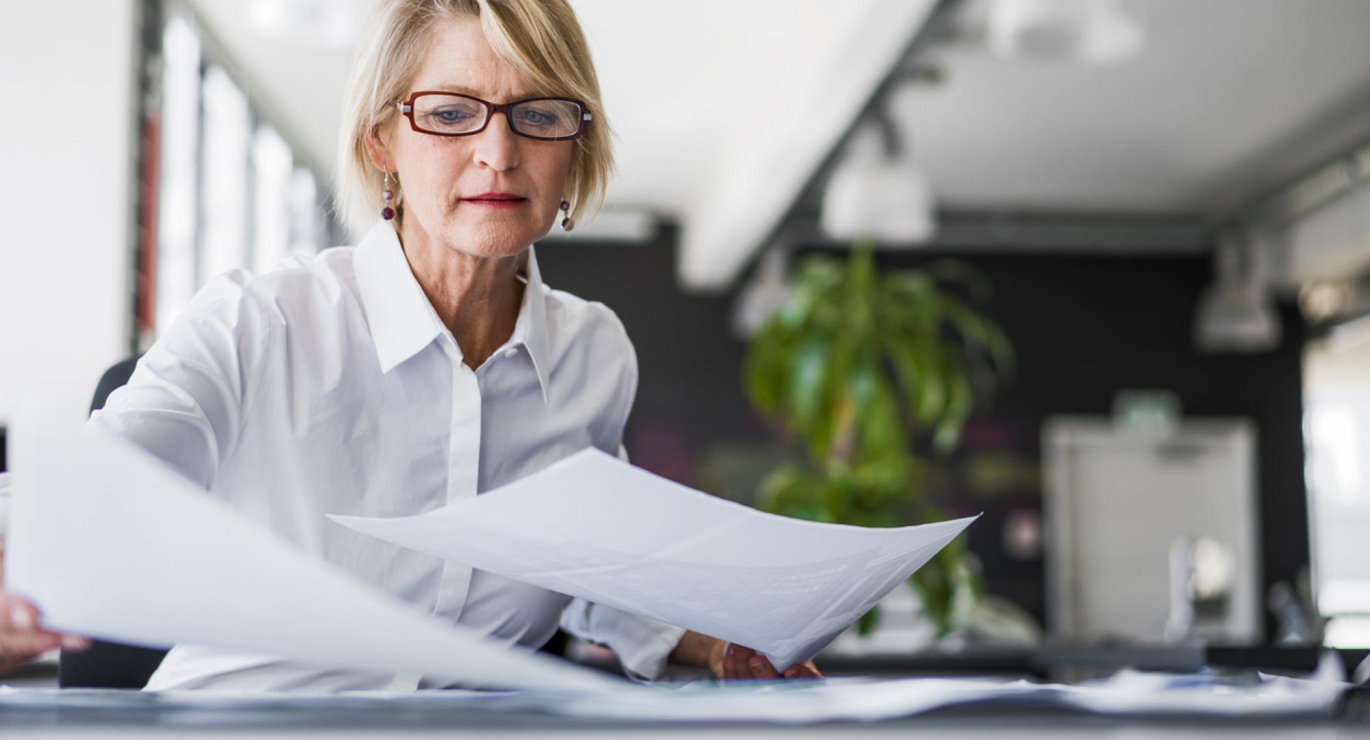 woman looking at sheets of paper