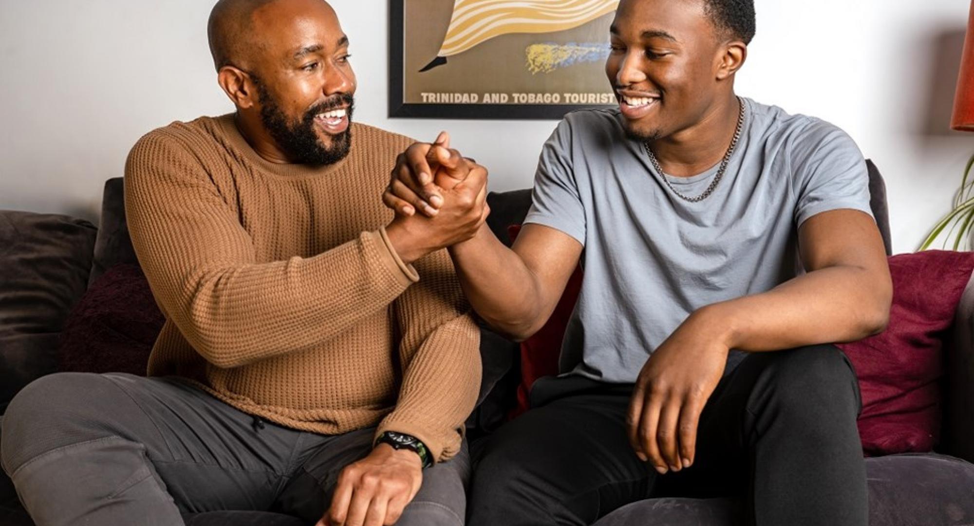 Two young men sat on a sofa