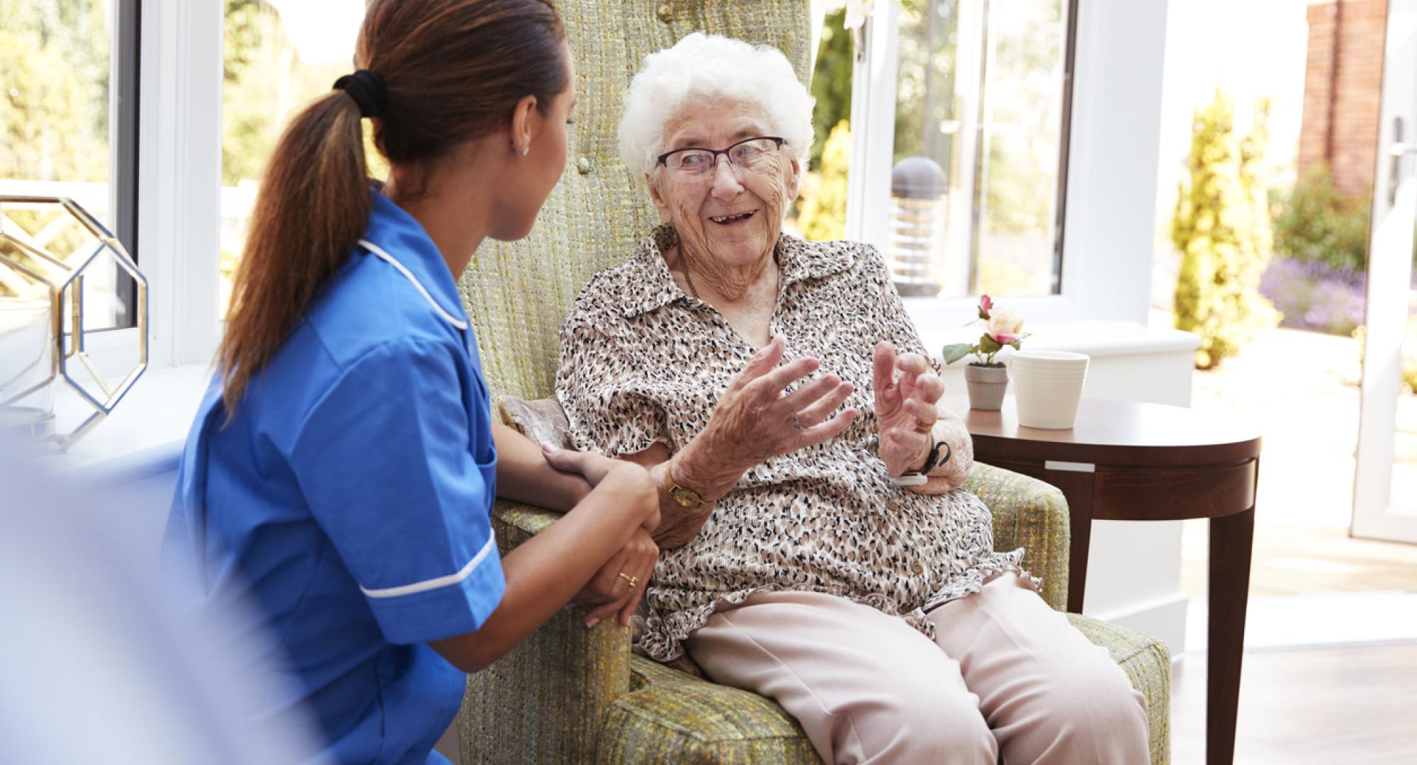 Elderly lady sat with carer