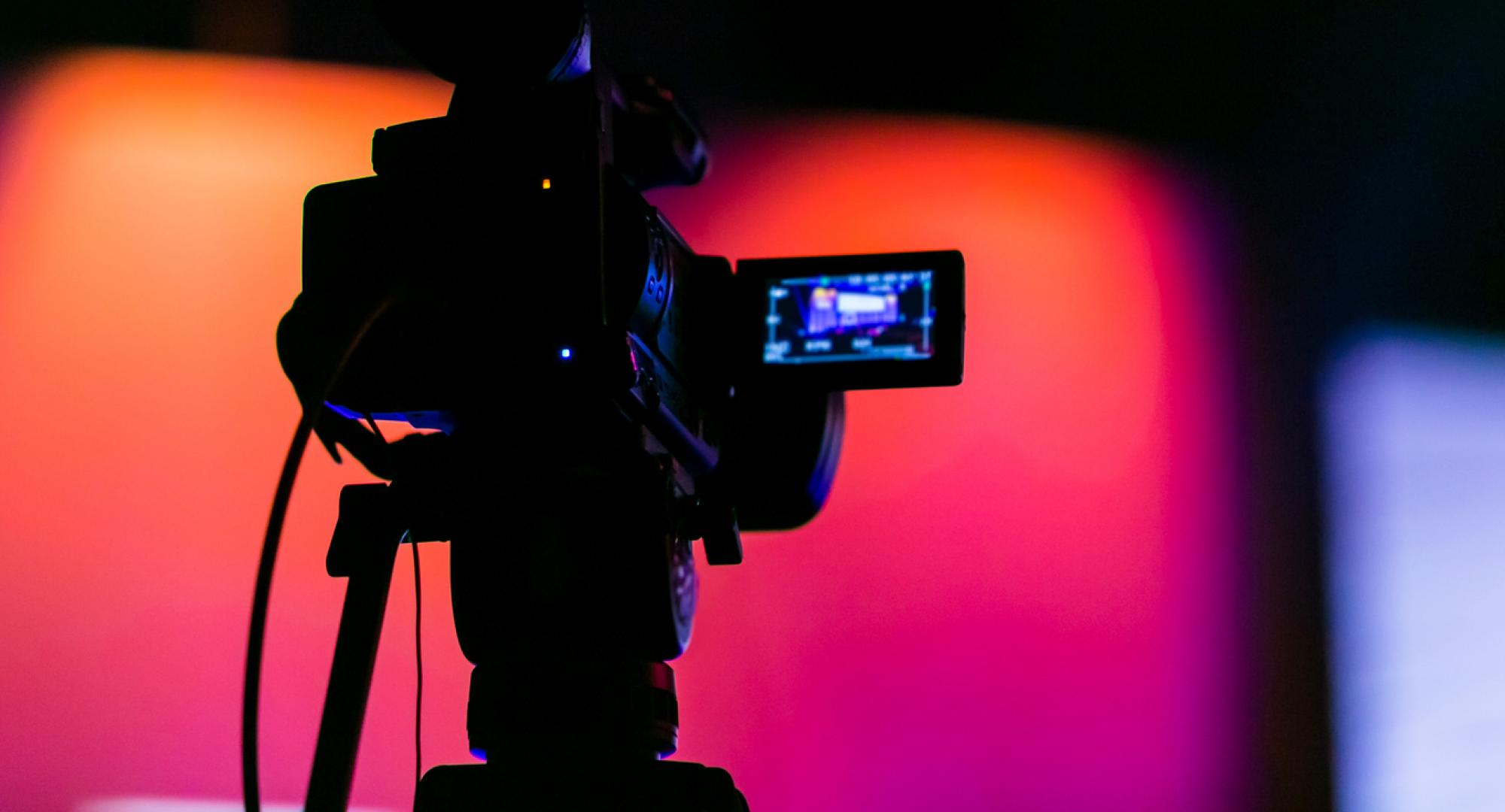 Silhouette of a camera filming