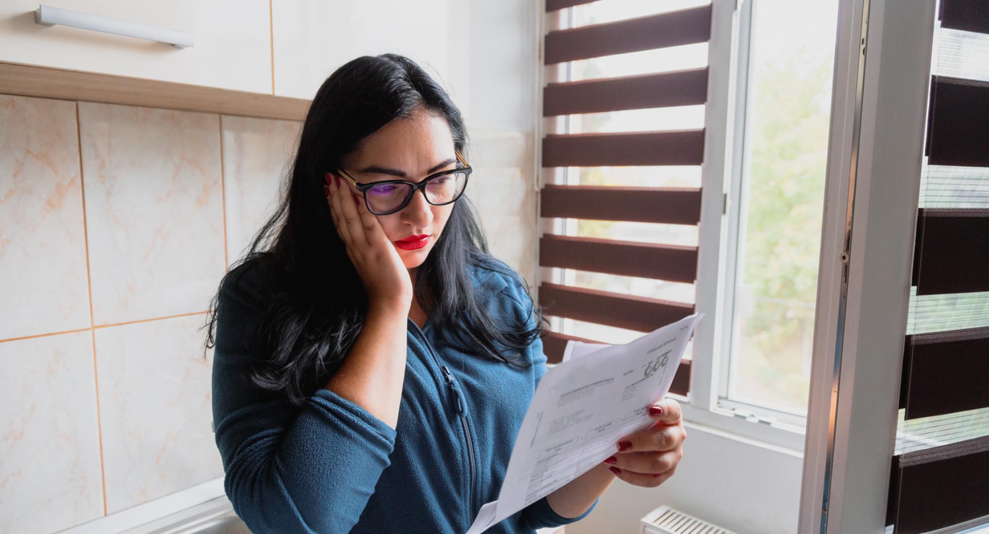 Portrait of a mid adult woman checking her energy bills at home