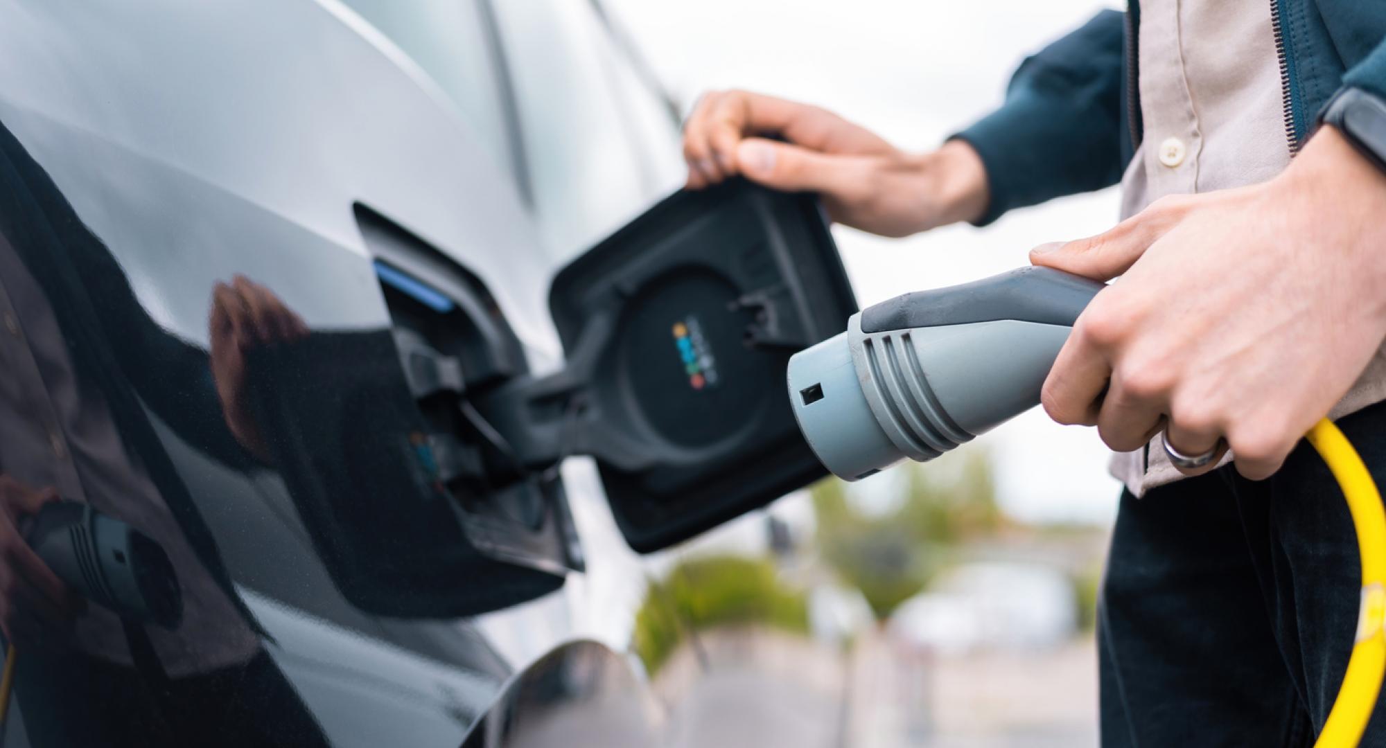 Man using electric vehicle charger