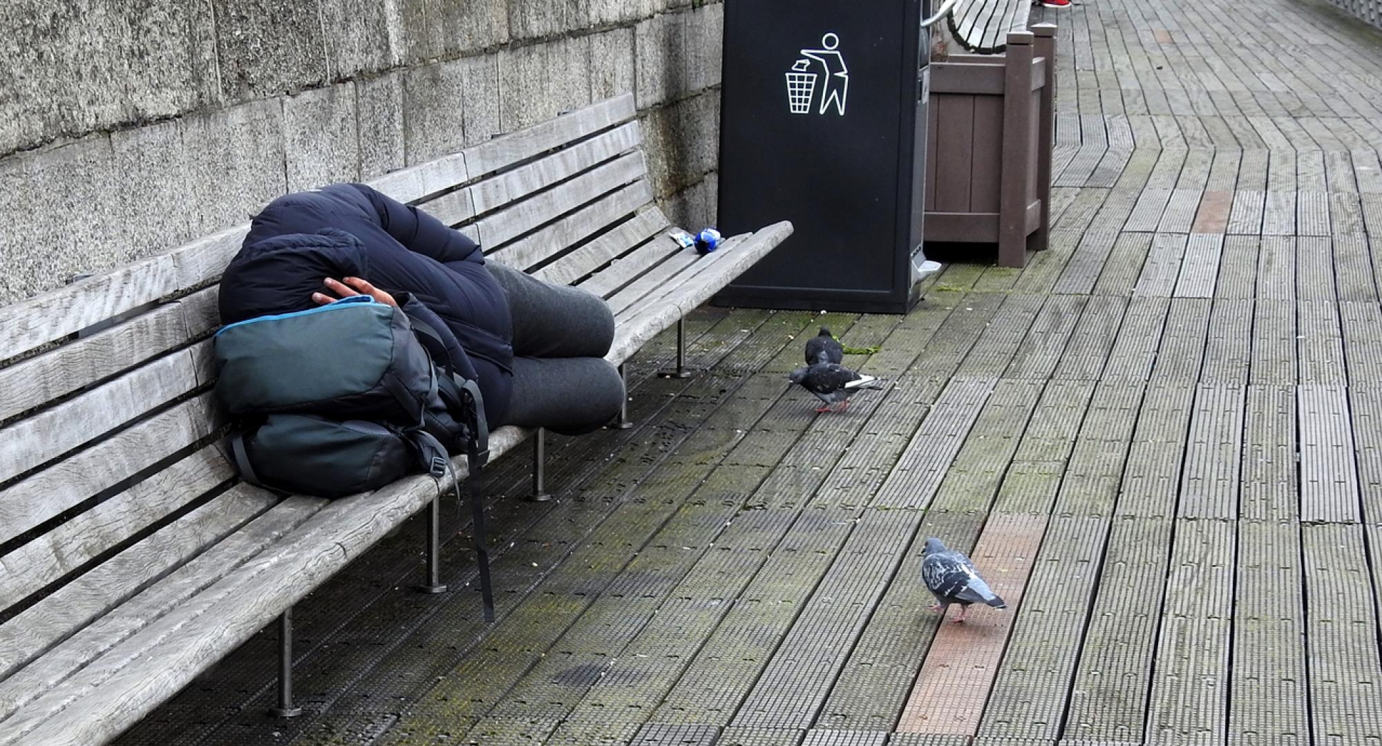 Homeless man sleeping on a bench
