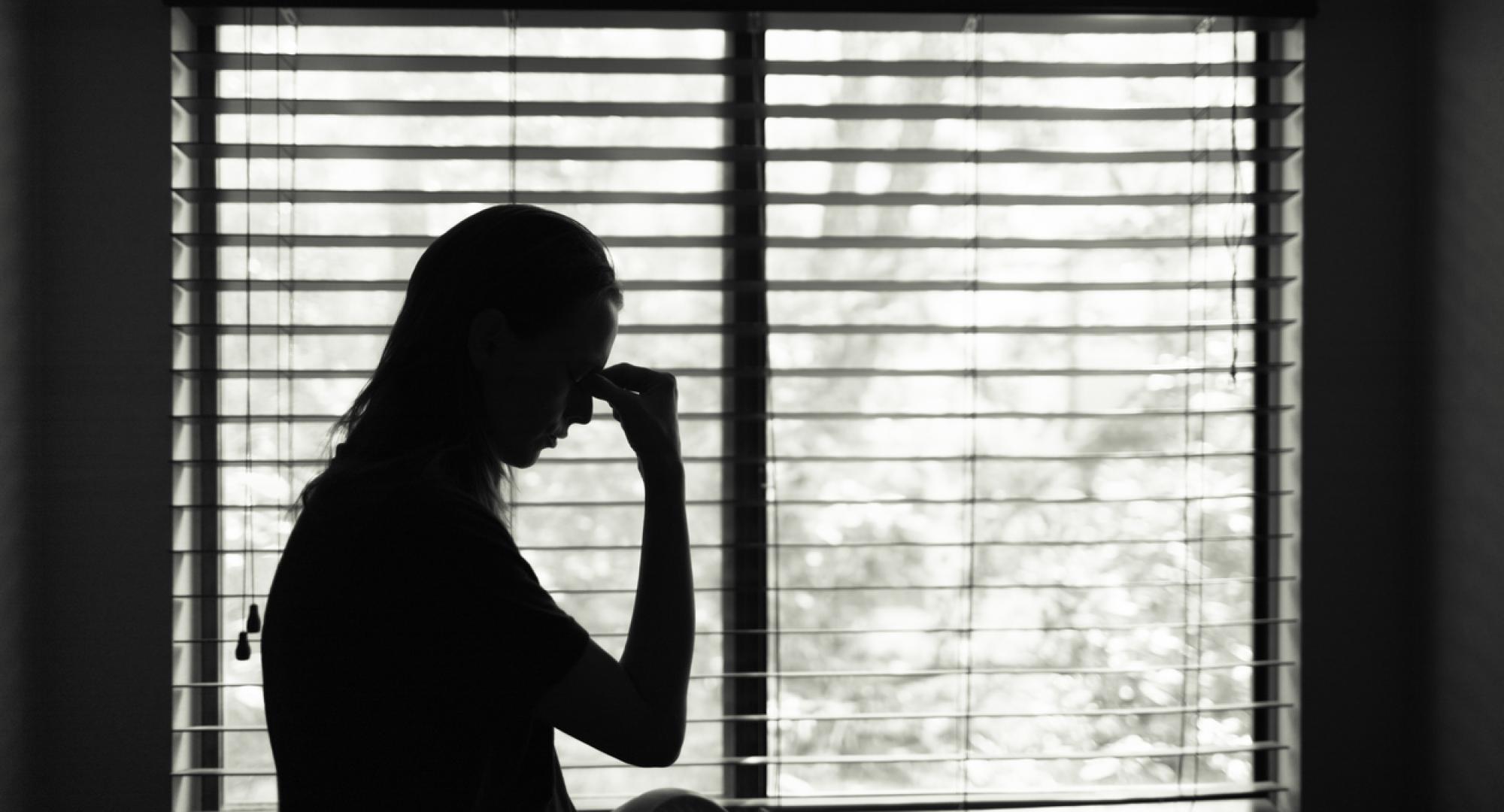 Silhouette of woman looking sad