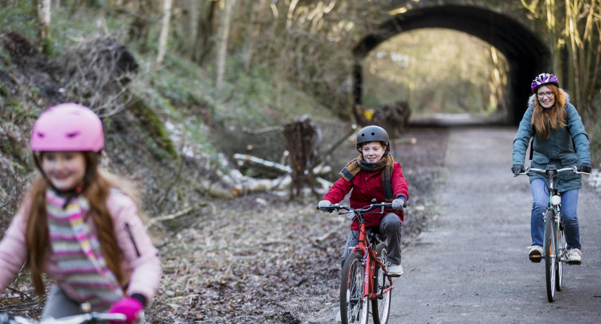 A family cycling through a park