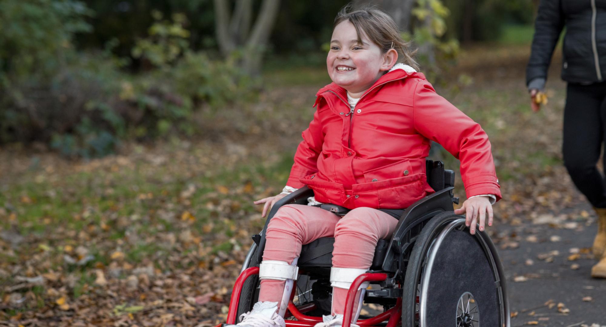 Picture of a young girl in a wheelchair in a public park
