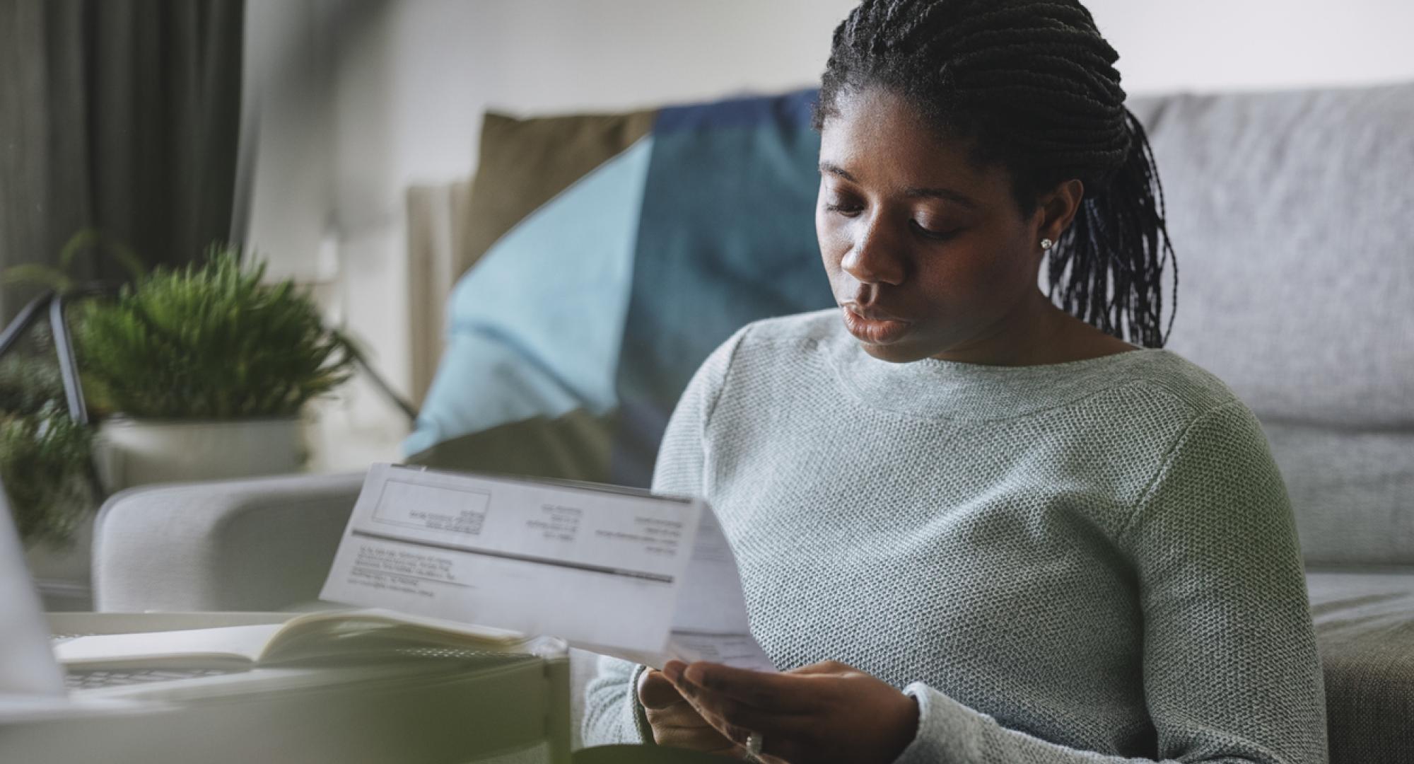 Young woman reading energy bill looking concerned