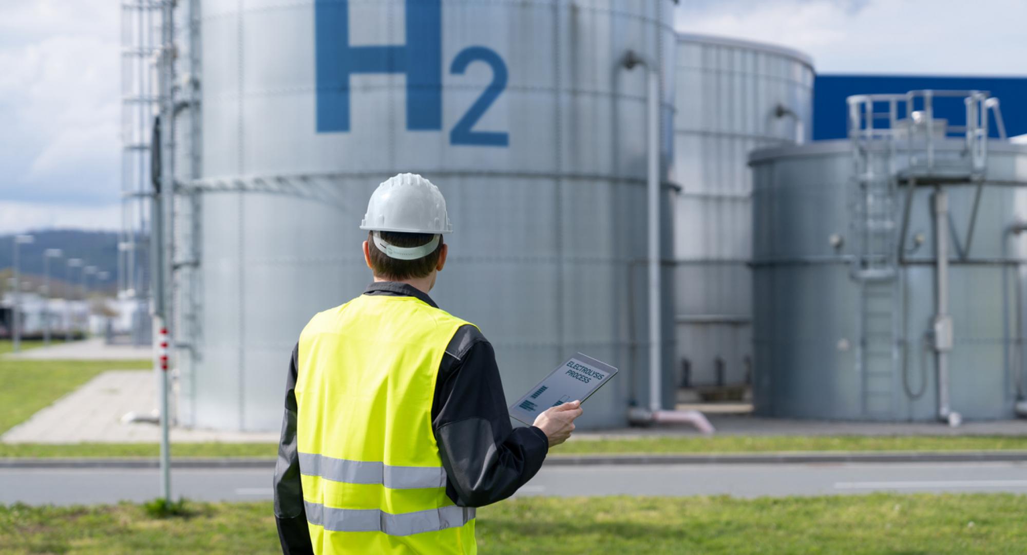 Man in hi vis in front of a hydrogen storage tank